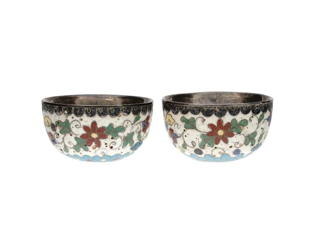 A pair of antique Japanese Meiji Era brass and enamel sake cups, circa: early 20th century. The wares are enameled with polychrome wavy, swirl, floral, and foliage patterns made in the Cloisonne technique. Unmarked. Antique and Vintage Asian and
