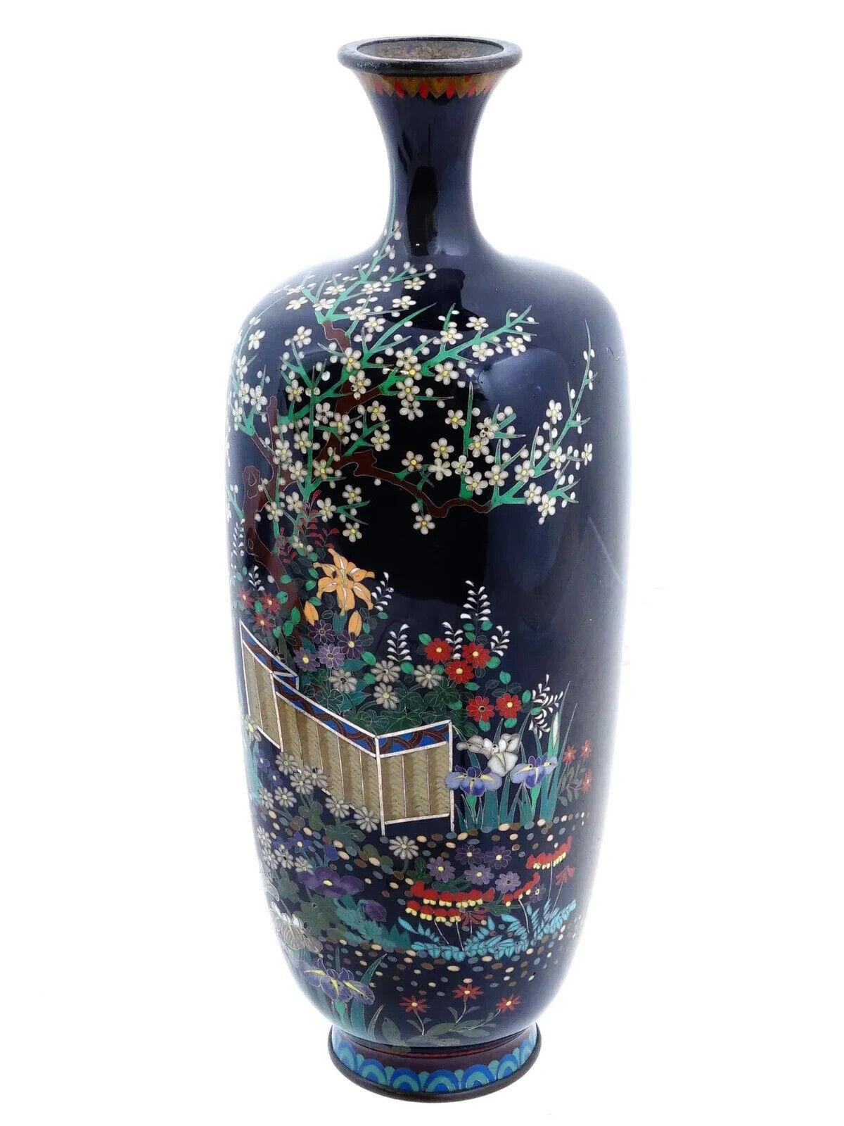 Vaso di gemme giapponese in filo d'argento e smalto. Il vaso è smaltato con un disegno di giardino policromo con fiori e alberi in fiore realizzato con la tecnica Cloisonne su fondo blu scuro. La merce è decorata con un motivo ondulato sulla base.