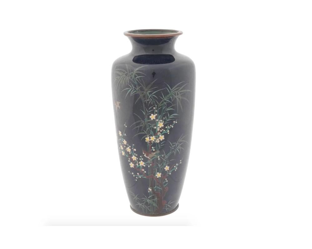 An antique Japanese Meiji period cloisonne vase of a baluster shaped body rising from a slightly spreading foot to a broad waisted neck and everted rim, decorated with a floral images worked in silver wire and enamels, set against a blue ground.