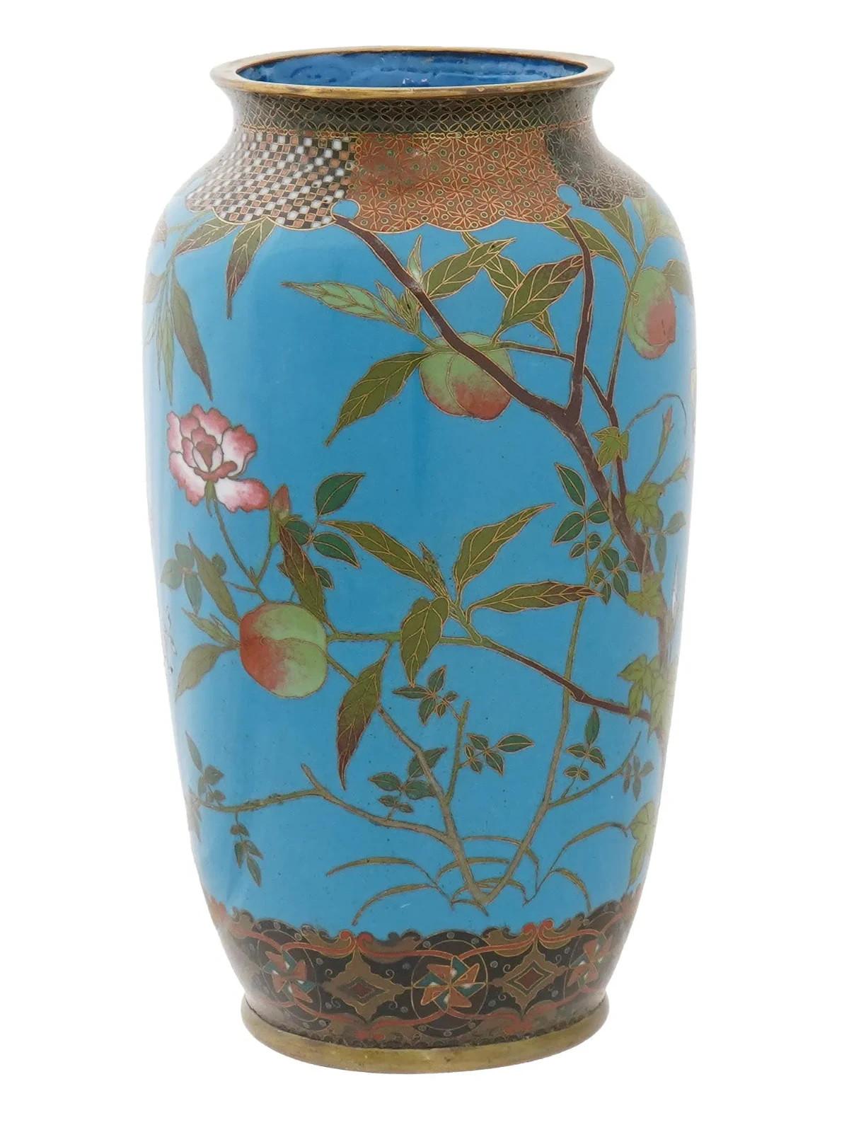 An antique Japanese cloisonne vase from the Meiji period featuring an elegant form with high shoulders and a deep saturated blue color enamel. Decorated with floral and foliate with butterflies images to the body. A rim and base are decorated with
