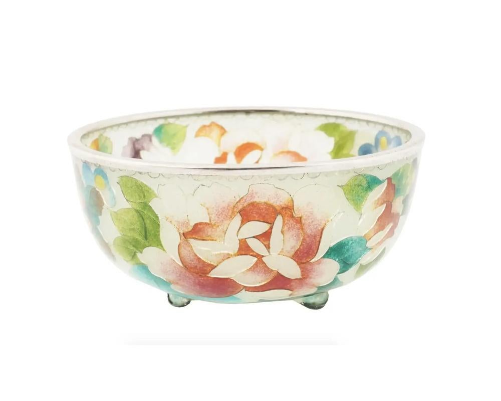 An antique Japanese Meiji era enamel bowl. The bowl is covered with polychrome enamel foliage and floral patterns made in the Plique a Jour technique. Mounted on three legs. Circa: early 20th century. Unmarked. Plique a jour is a vitreous enamelling