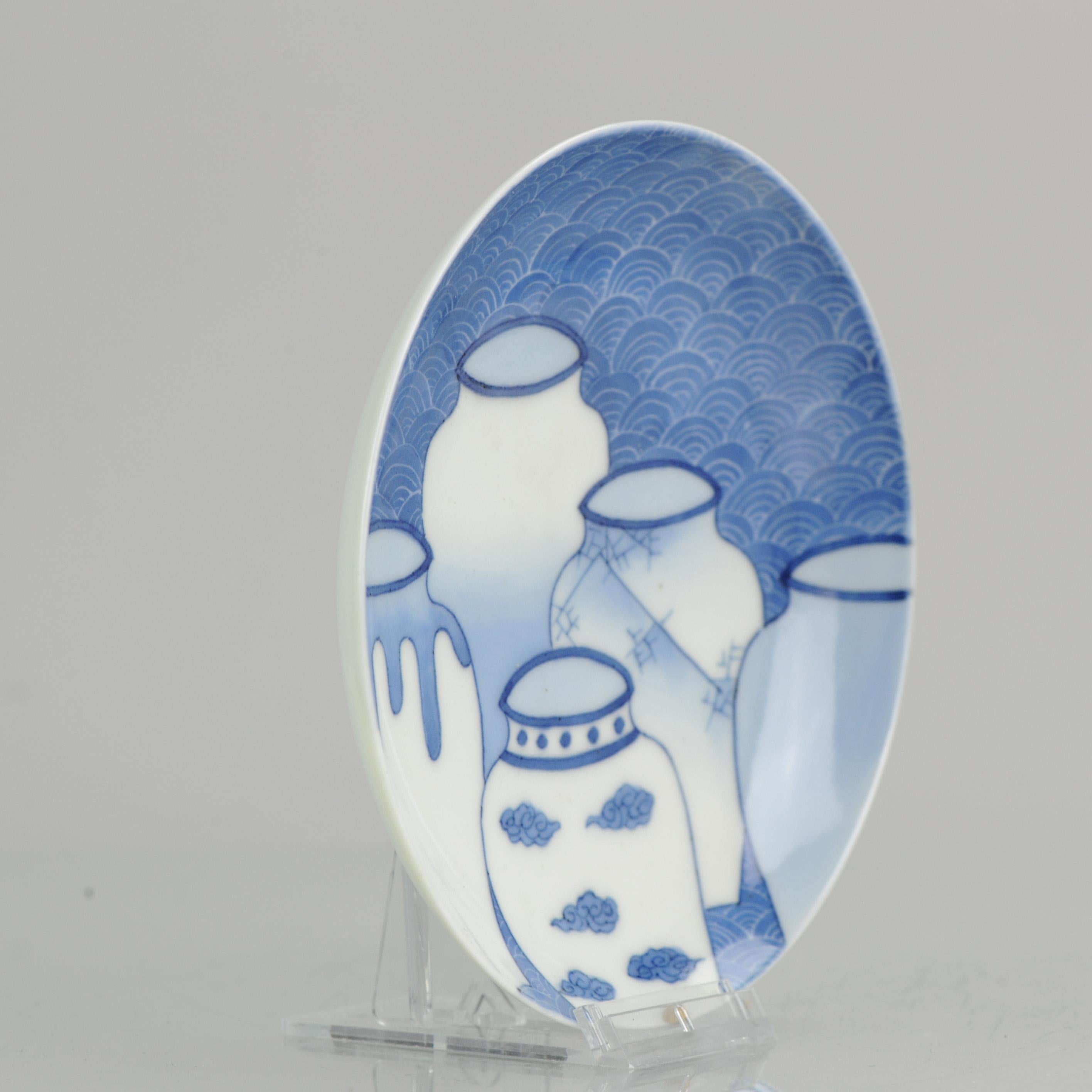 Un cuenco/plato con pie muy bonito y agradable de nabeshima. Escena central de 5 jarrones sobre fondo ondulado en azul bajo vidriado.

Más información:
Material: Porcelana y cerámica
Tipo: Placas
Región de origen: Japón
Periodo: Siglo XIX Periodo