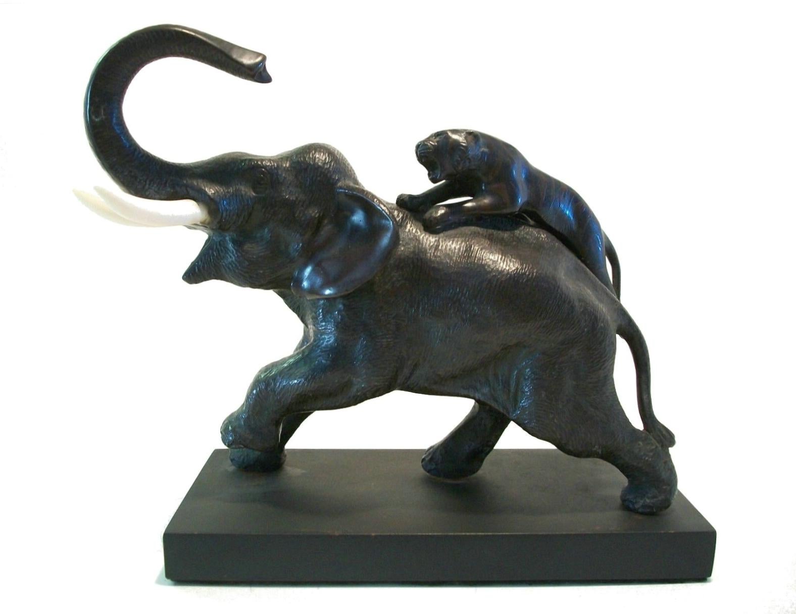 Antique Meiji Period bronze and bone sculpture - dramatic fine casting of an elephant and tiger - mounted to an black painted wood base - unsigned - Japan - late 19th century.

Excellent antique condition - replaced plinth/base with scuffs and