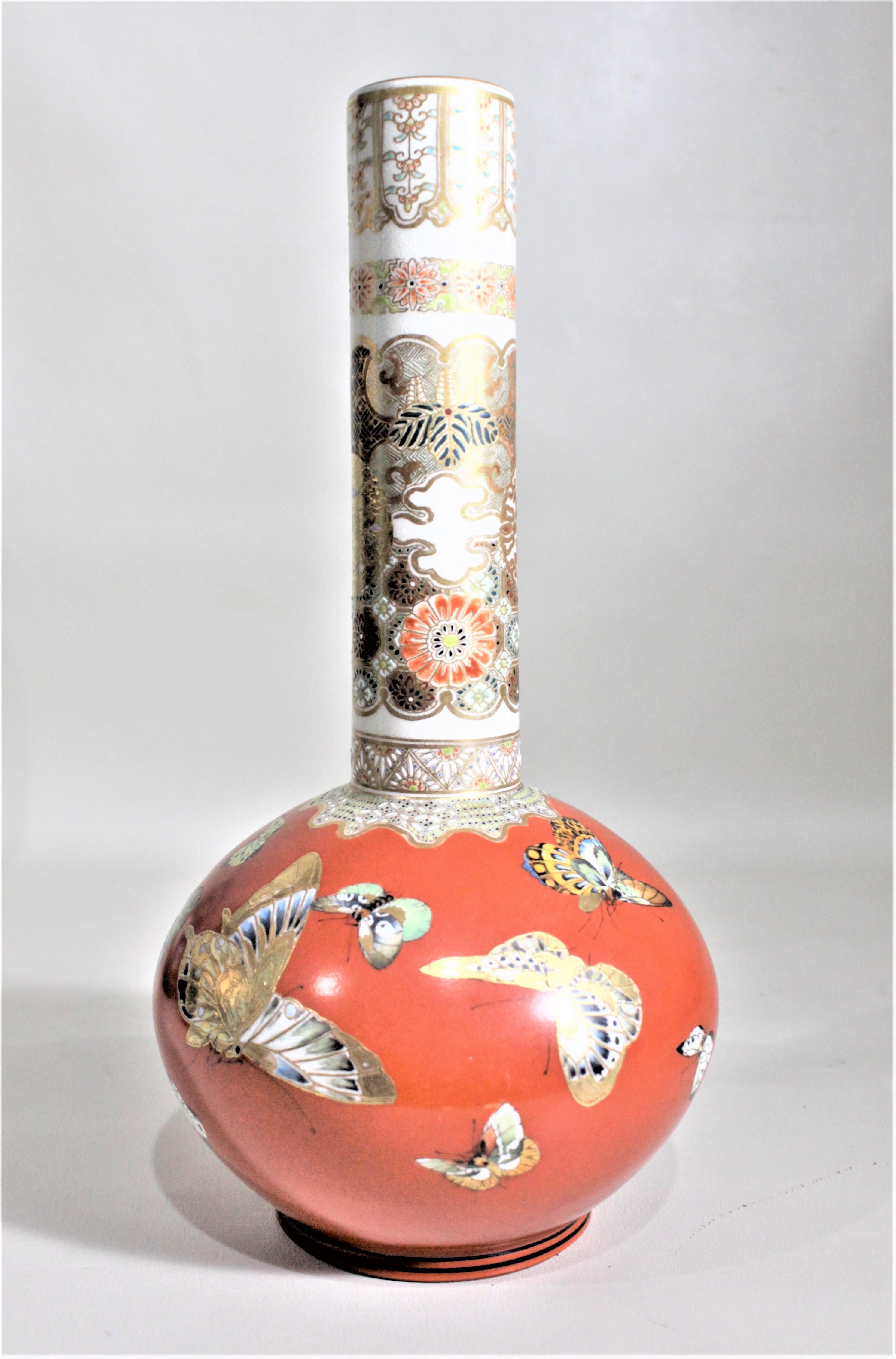This large antique earthenware vase was made in Japan is circa 1900 in the Meiji period and style. This vase stands a foot high and is done with a very vibrant orange ground with numerous well executed butterflies in flight in varying sizes around
