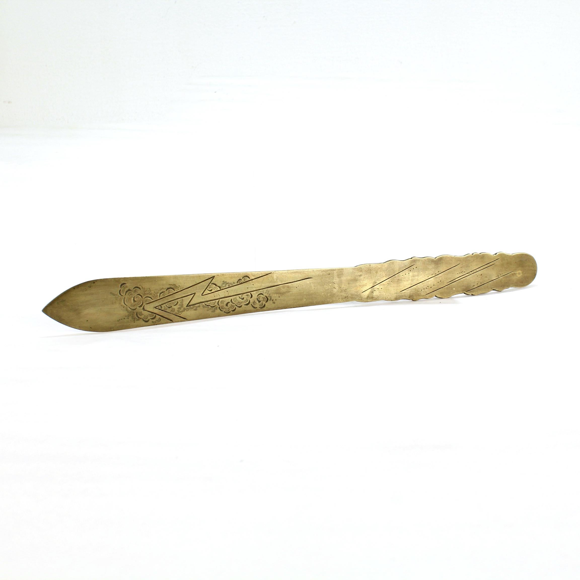 A very fine antique bronze Japanese letter opener.

The handle is decorated to the front with an embossed Eastern dragon amidst the clouds. The reverse of the handle has a simple or minimalist depiction of rain.

The blade is decorated to both