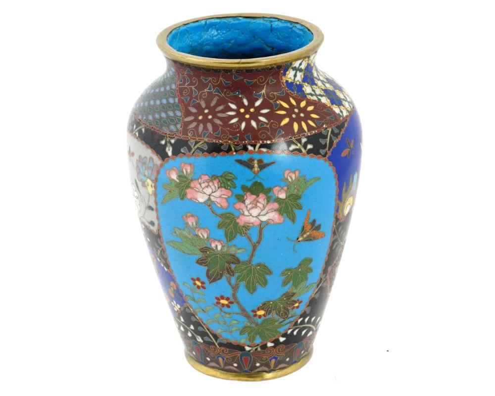 Antico vaso giapponese in cloisonne del periodo Meiji con intricati motivi di fogliame completati da due squisiti pannelli floreali. La meticolosa maestria nella raffigurazione di motivi di fogliame sul corpo dei vasi mette in mostra l'abilità e la