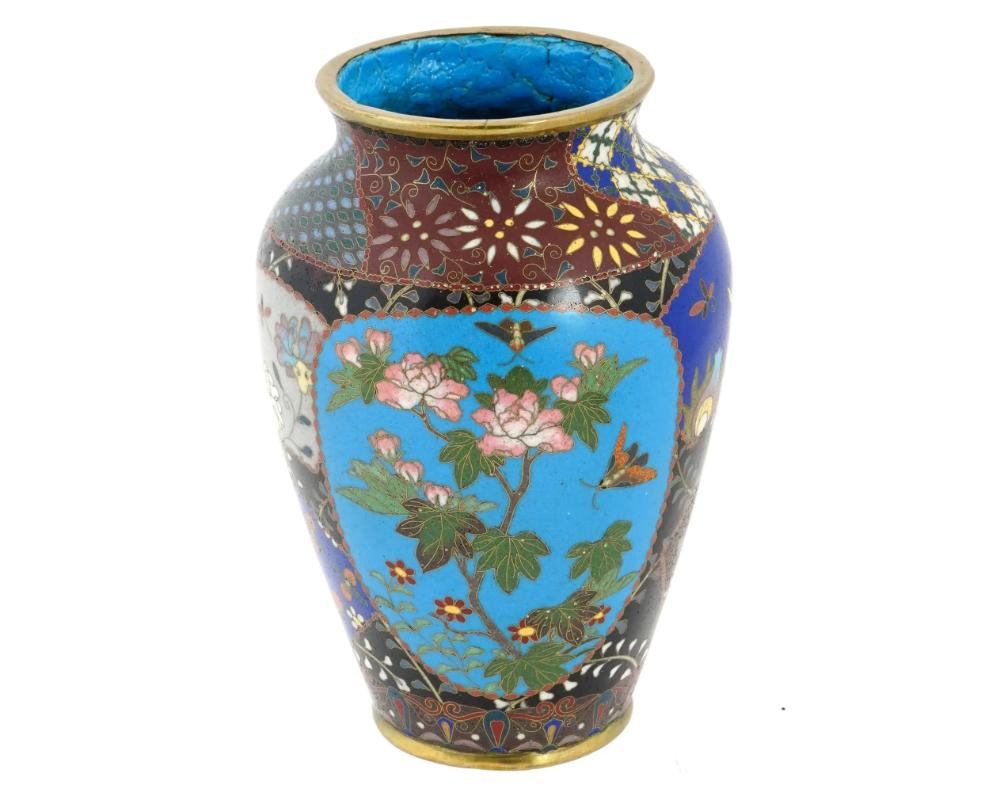 Ancien vase japonais en cloisonné de la période Meiji, présentant des motifs de feuillage complexes complétés par deux panneaux floraux exquis. Le travail méticuleux des artisans qui ont représenté des motifs de feuillage sur le corps des vases