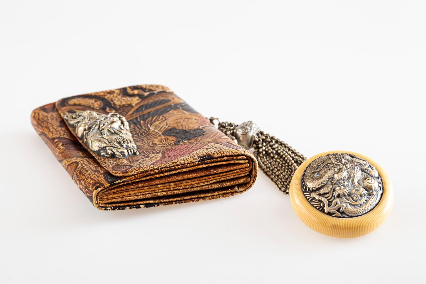 Wirbelnde handgemalte Farben auf Leder zeigen einen geflügelten Engel auf dieser schönen japanischen Brieftasche aus der Meiji-Ära in Japan, ca. 1868- 1912. Die geprägten Farben sind rot, gold, braun und schwarz.
Die Brieftasche wird als Inro