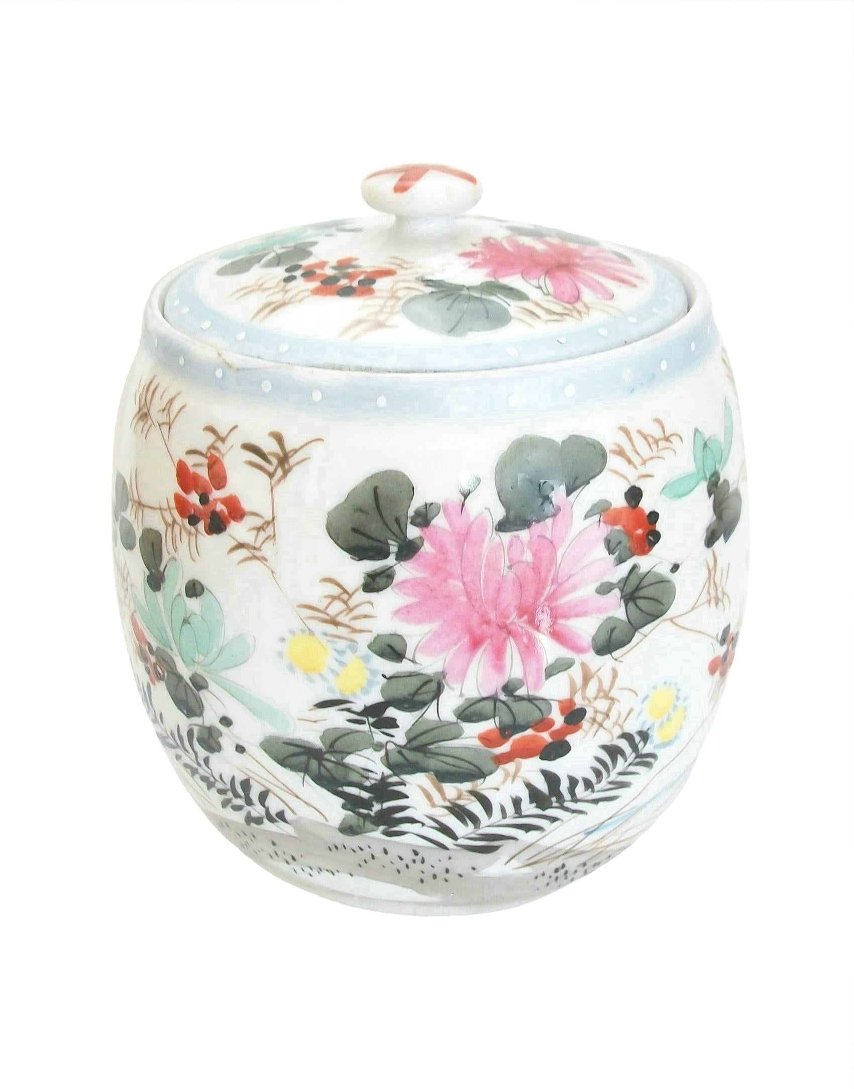 Antique Meiji period Wucai style hand painted porcelain jar and cover - featuring flowering branches of multicolor blossoms and leaves - all on a white ground with pale blue rim to the jar and lid - unglazed foot rim and base - unsigned - Japan -