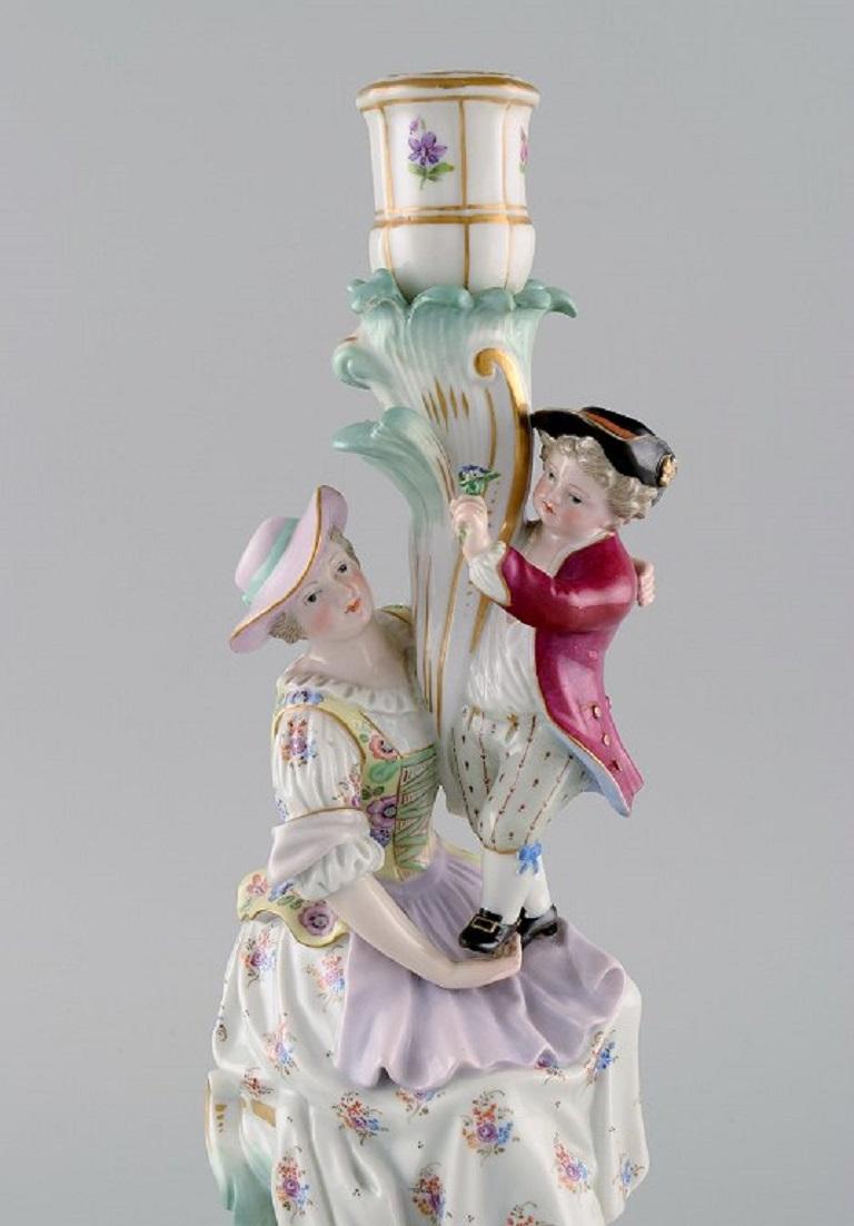 Antique Meissen candlestick in hand-painted porcelain. 
Mother and boy with flowers. Late 19th century.
Measures: 31.5 x 17 cm.
In excellent condition. Minimal chip on the boy's flowers.
Signed.
1st Factory quality.