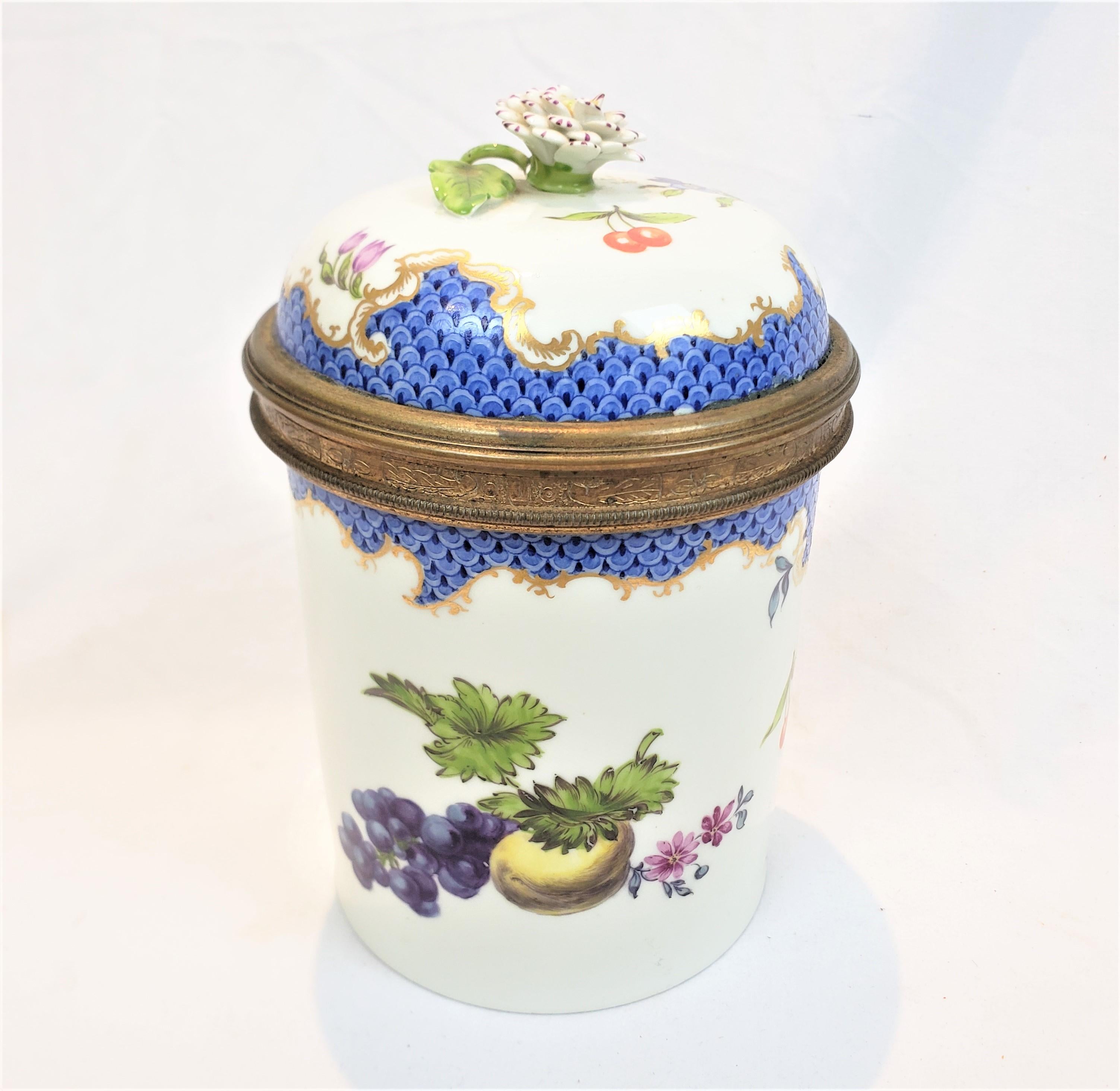 This antique covered jar or pot was made by the well known Meissen factory of Germany in approximately 1750 in the period Louis XV style. This lidded jar is made of porcelain with bronze collars, with an ornate figural carnation handle with