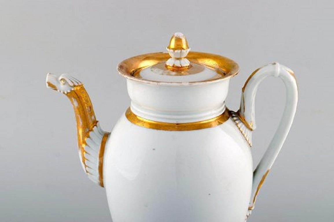 Antica caffettiera Impero di Meissen con decorazione dorata. XIX secolo.
Misure: 27 x 20 cm.
Prima qualità di fabbrica.
In buone condizioni, con usura dell'oro.
Timbrato.
   