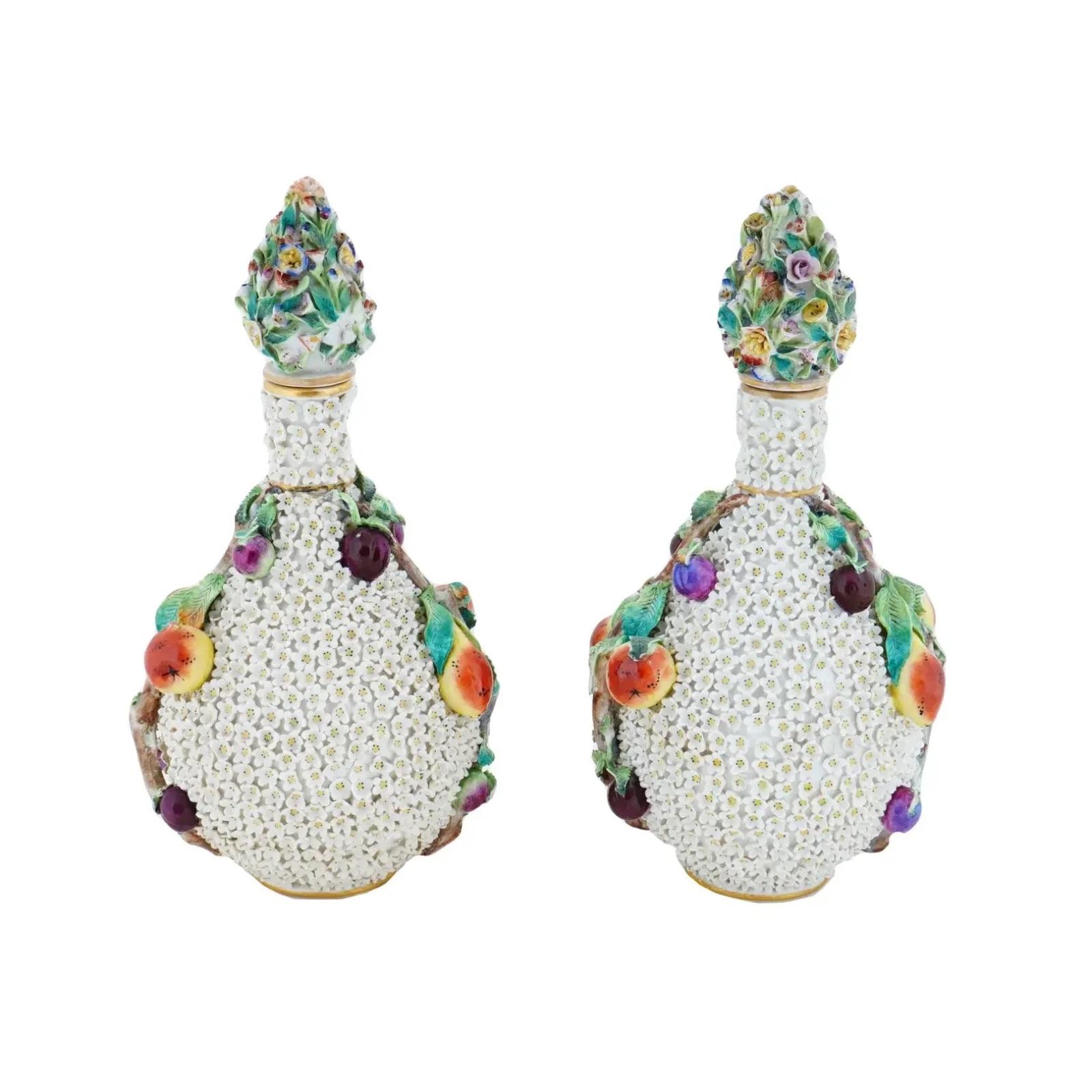 Coppia di antichi vasi per bottiglie con coperchio Schneeballen di Meissen. Ogni vaso ha un collo in vermiculite dorata, fiori bianchi applicati e rami con frutti applicati sui lati. I coperchi sono decorati con fiori policromi in rilievo. Marcato