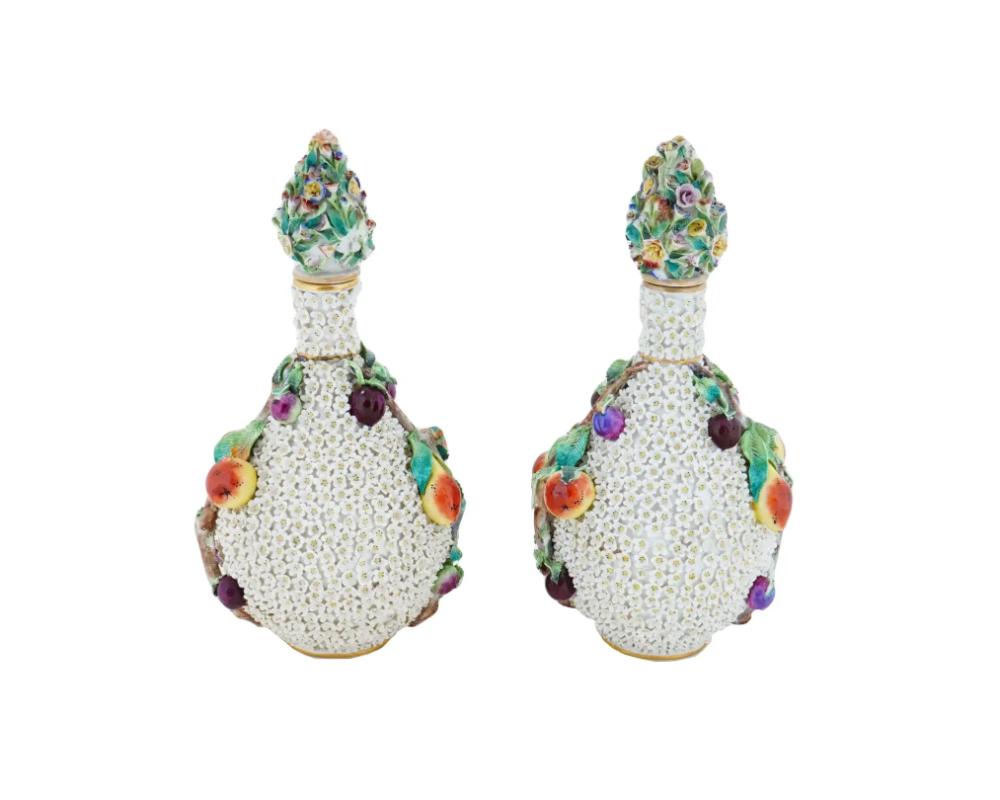 A pair of antique German Meissen manner Schneeballen Snowball lidded bottle vases. Each vase has a gilt vermiculite neck, applied white florals, and applied branches with fruits, on the sides. The lids are decorated with polychrome relief flowers.