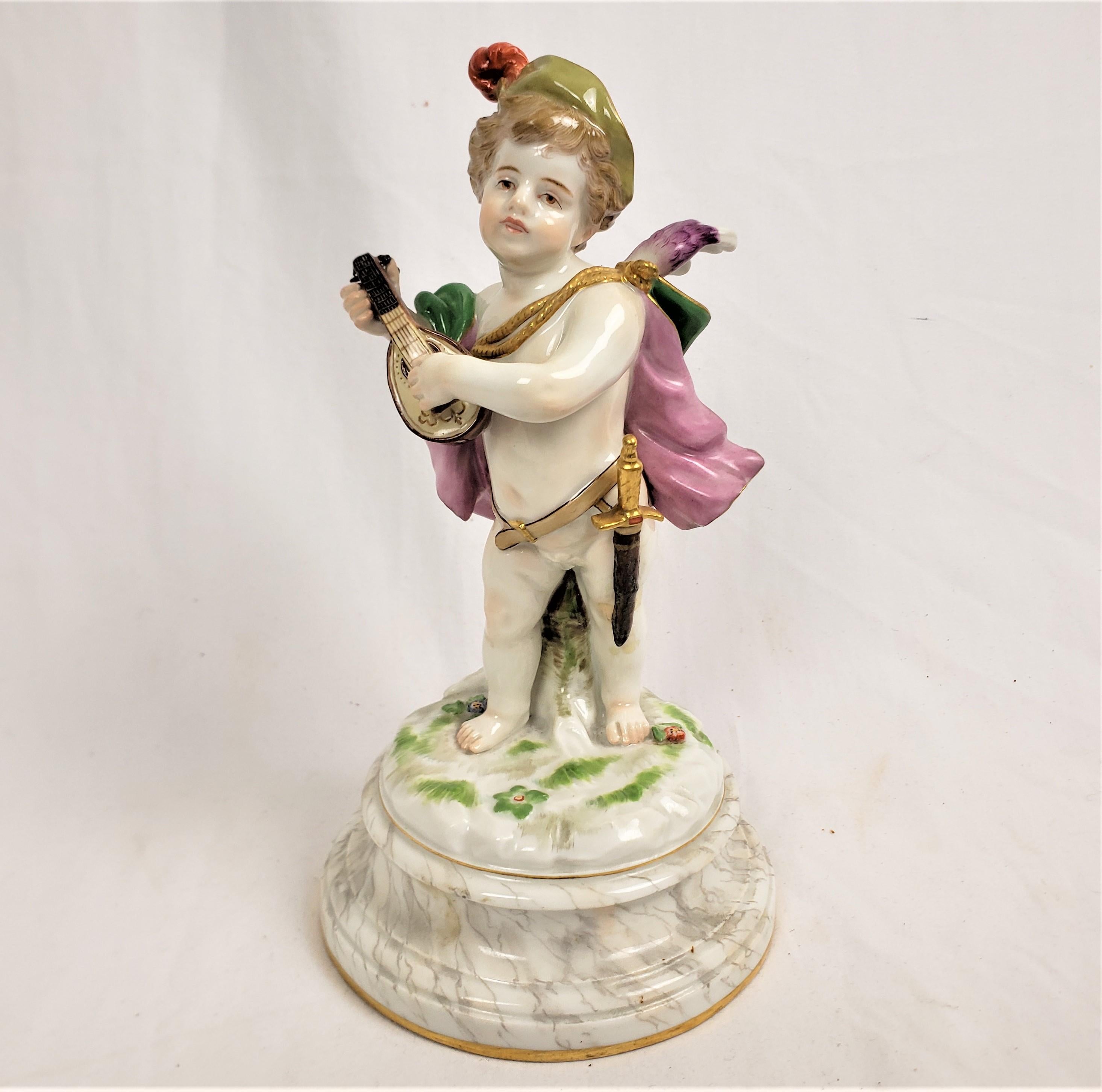 This antique figurine was made by the renowned Meissen factory of Germany in approximately 1850 in their period Dresden romantic style. The figurine is composed of their paste porcelain and depicts a young child wearing a cape and cap and sword,