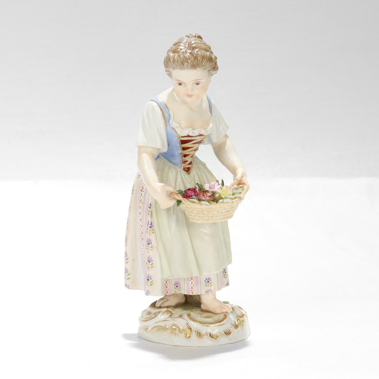 A fine antique German porcelain figurine.

By Meissen.

In the form of a barefoot young girl in a dirndl dress carrying a wicker basket full of many different flowers. Atop a Rococo-style gilt plinth.

Marked to the base with Meissen's blue