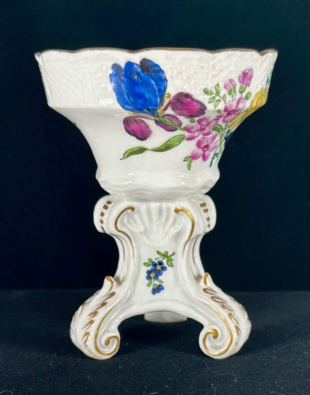 Antique Meissen Porcelain Footed Salt Cellar ca. 1735 Hand Painted

Rare Meissen porcelain salt cellar on three voluted feet accented in gold and polychromed. The tapered, circular bowl with basketweave border is polychrome hand painted in overglaze