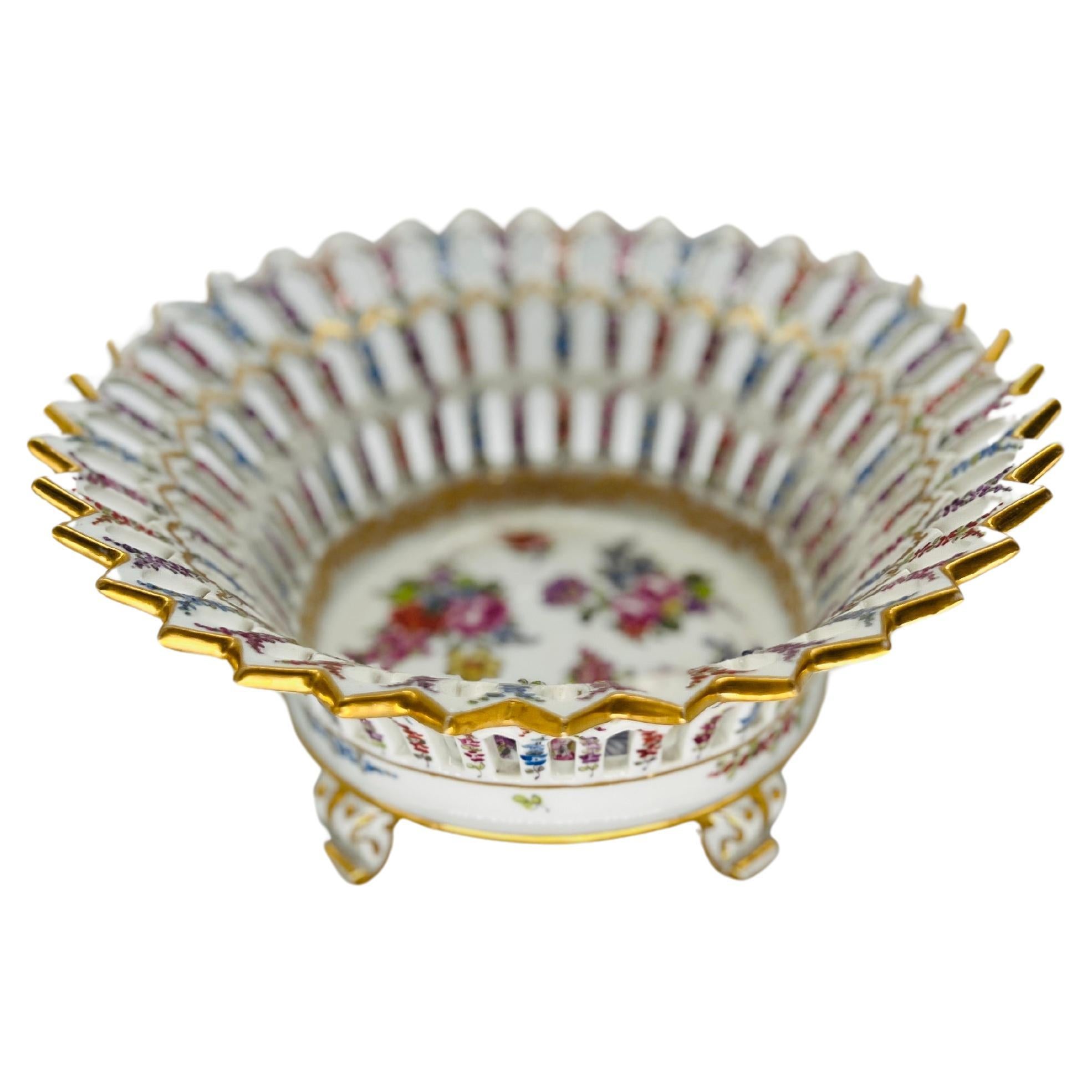 Dieser exquisite antike Obstkorb aus Meissener Porzellan mit Blumendekor aus der Zeit um 1920 verkörpert die zeitlose Eleganz und Handwerkskunst, für die die berühmte Meissener Porzellanmanufaktur bekannt ist. Das kunstvoll aus feinem Porzellan