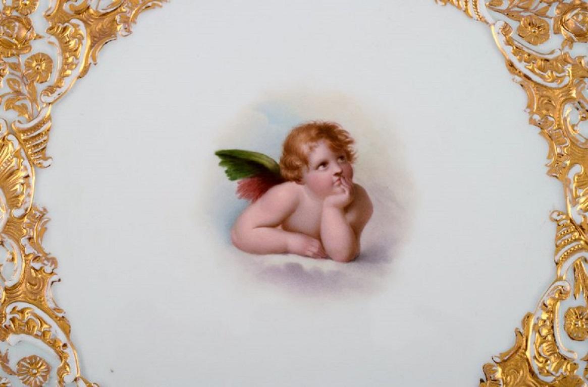 Antique Meissen porcelain plate with hand-painted gold decoration and putto after Raphael. 
Ca. 1900.
Measure: Diameter: 29 cm.
In excellent condition.
Stamped.
1st factory quality.