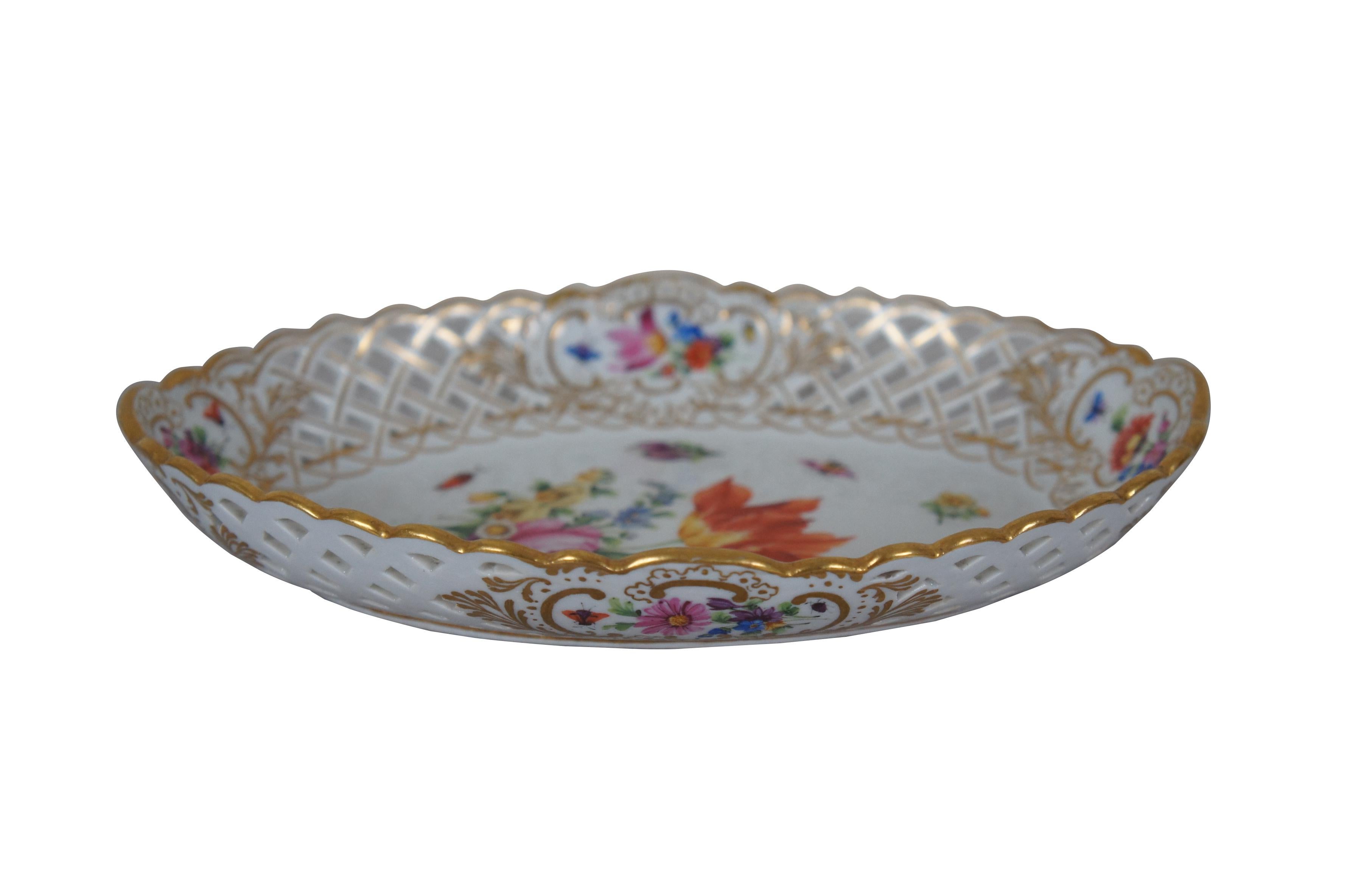 Early 20th century Meissen porcelain dish. Oval form with pierced basket weave sides, scalloped edge, hand painted with gilded details and multicolored sprays of flowers and insects. Incised number 3.

Dimensions:
8.5