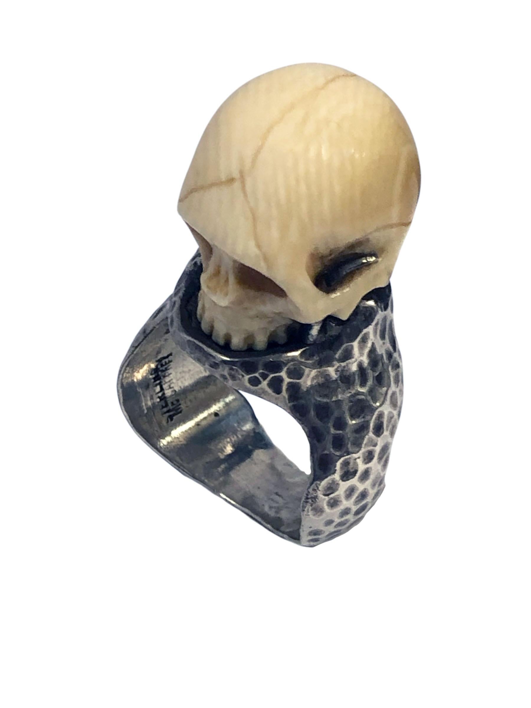 A Unique Memento Mori Ring comprised of an Antique carved Bone Skull that is incredibly detailed, the Skull measures 3/4 inch in height and 5/8 inch in diameter, the Skull is set on top of a Thick Hand Hammered finished Sterling Silver 1/2 inch wide