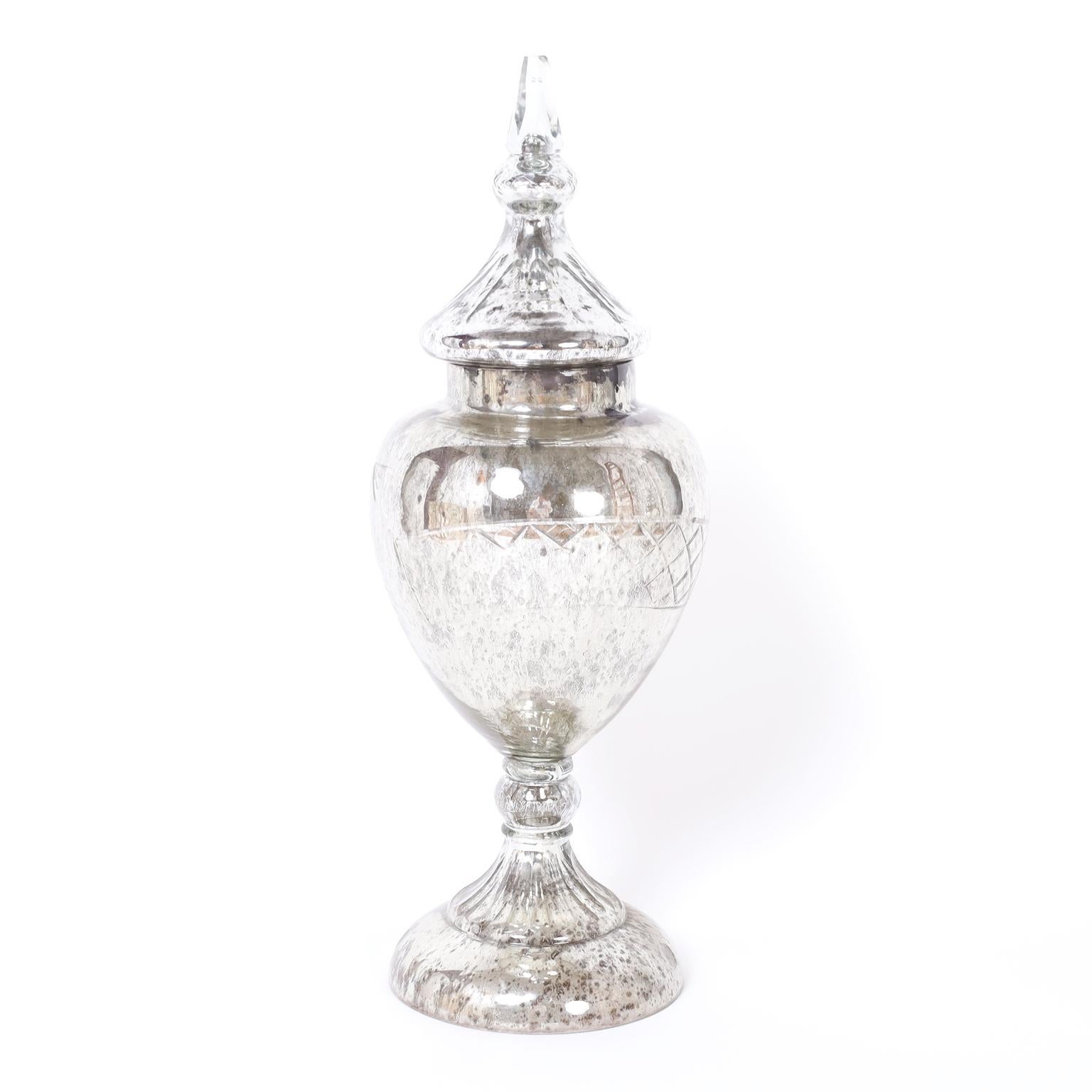 Pair of Victorian hand blown mercury glass lidded containers with classical form featuring cut geometric designs and an alluring time worn distressed finish.
