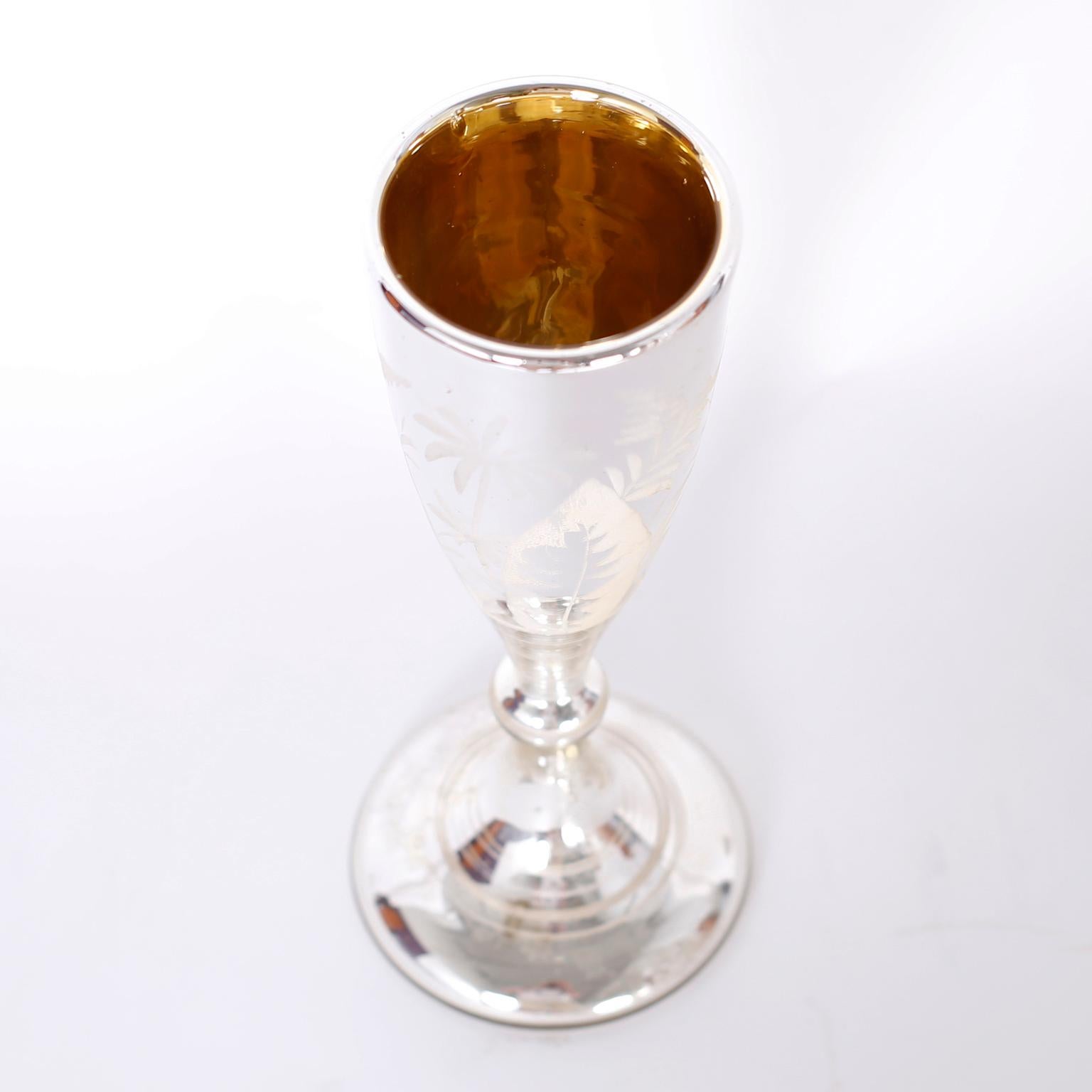 Enchanting antique mercury glass goblet with Classic form and featuring acid etched tropical designs and a gold tone interior.