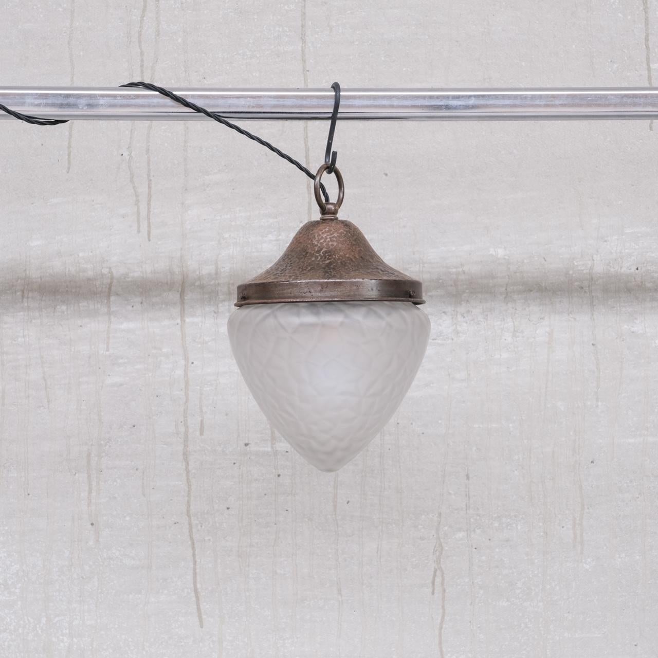 A curios opaque glass pendant light, with hand hammered metal gallery. 

France, c1930s. 

Good vintage condition, patina commensurate with age. 

Re-wired and PAT tested. 

No original chain or rose was retained but these are sourced easily