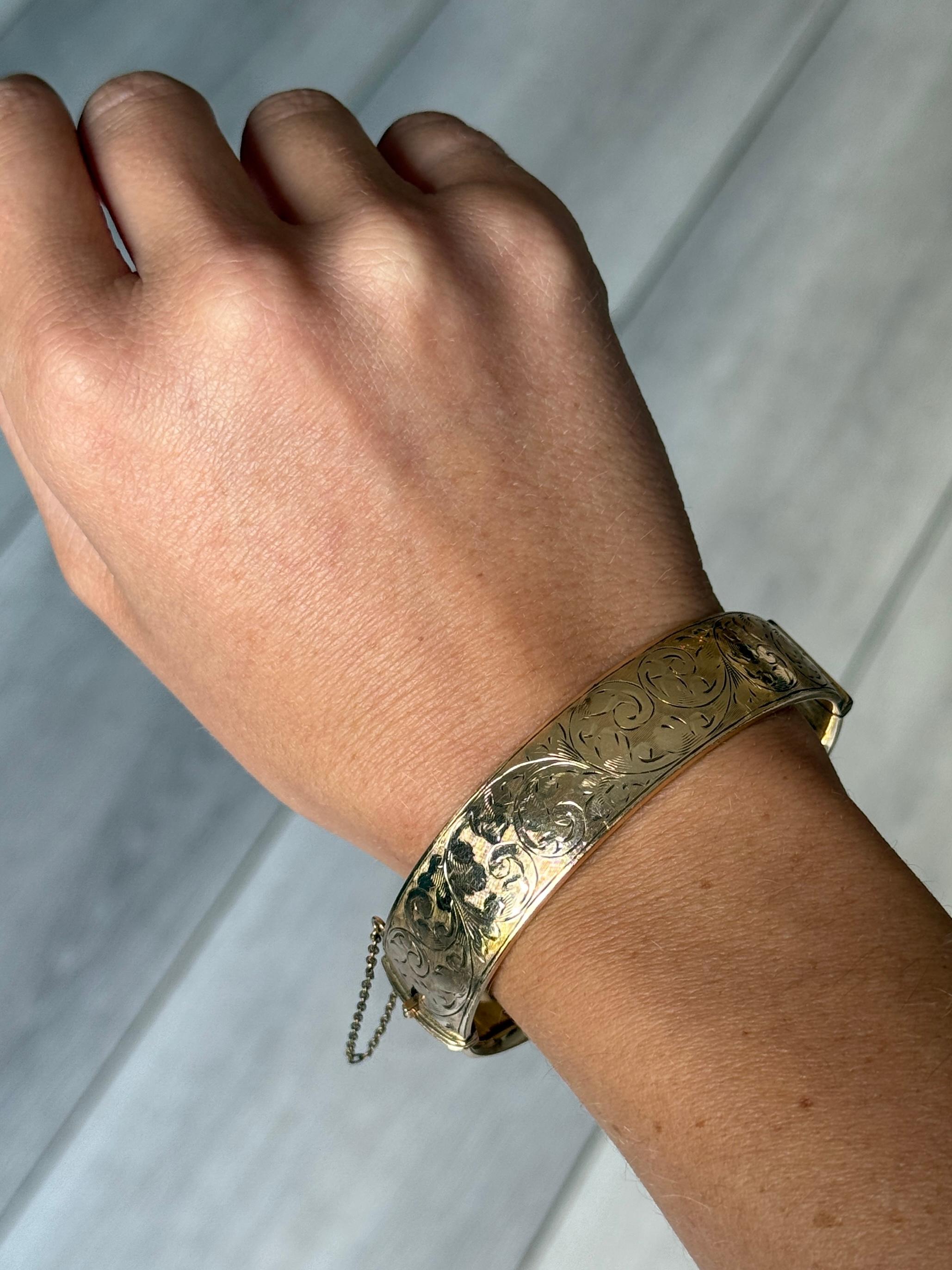 Este precioso brazalete de núcleo metálico tiene un maravilloso grabado y está recubierto de oro de 1/5 de 9 ct. 

Diámetro interior punto más ancho: 6.1 cm
Circunferencia interior:  18 cm
Ancho de la pulsera: 16 mm

Peso: 31 g