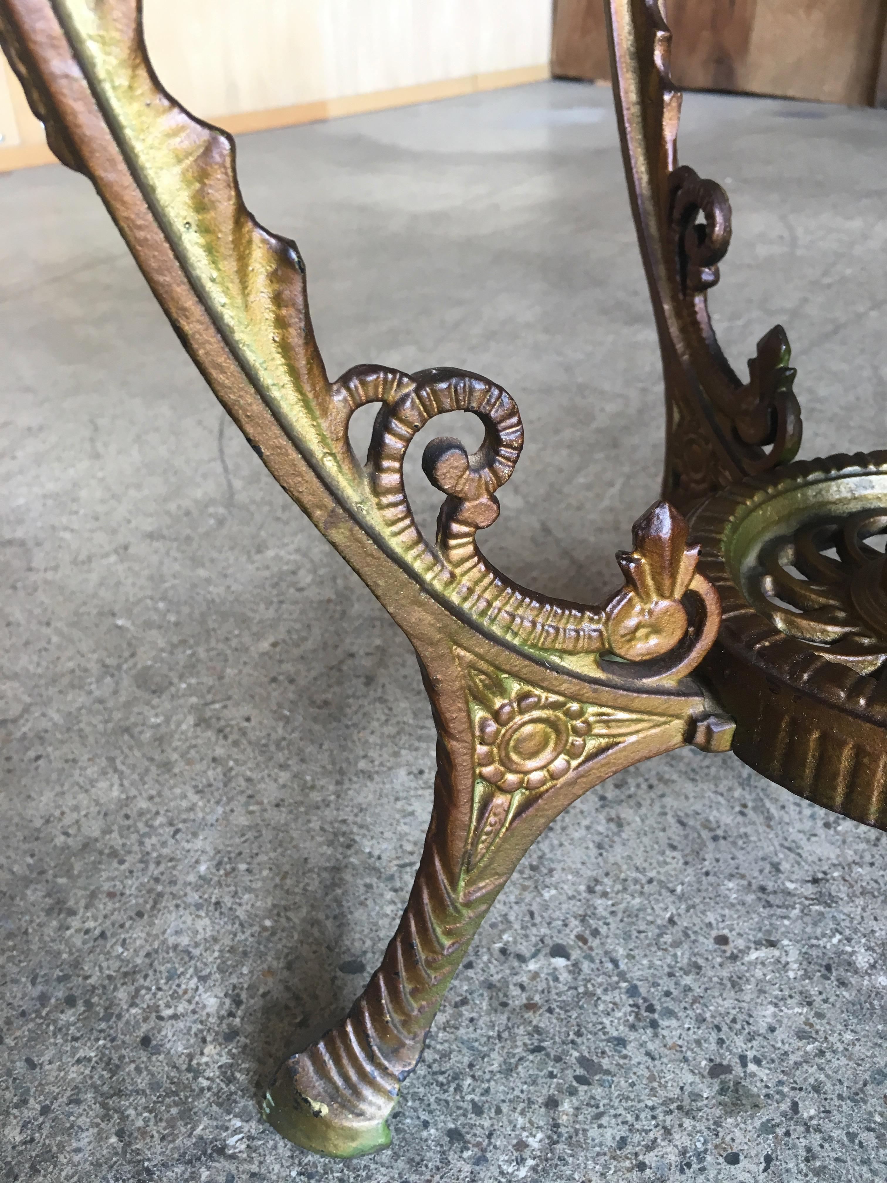 Gothic style metal end table with polychrome top.