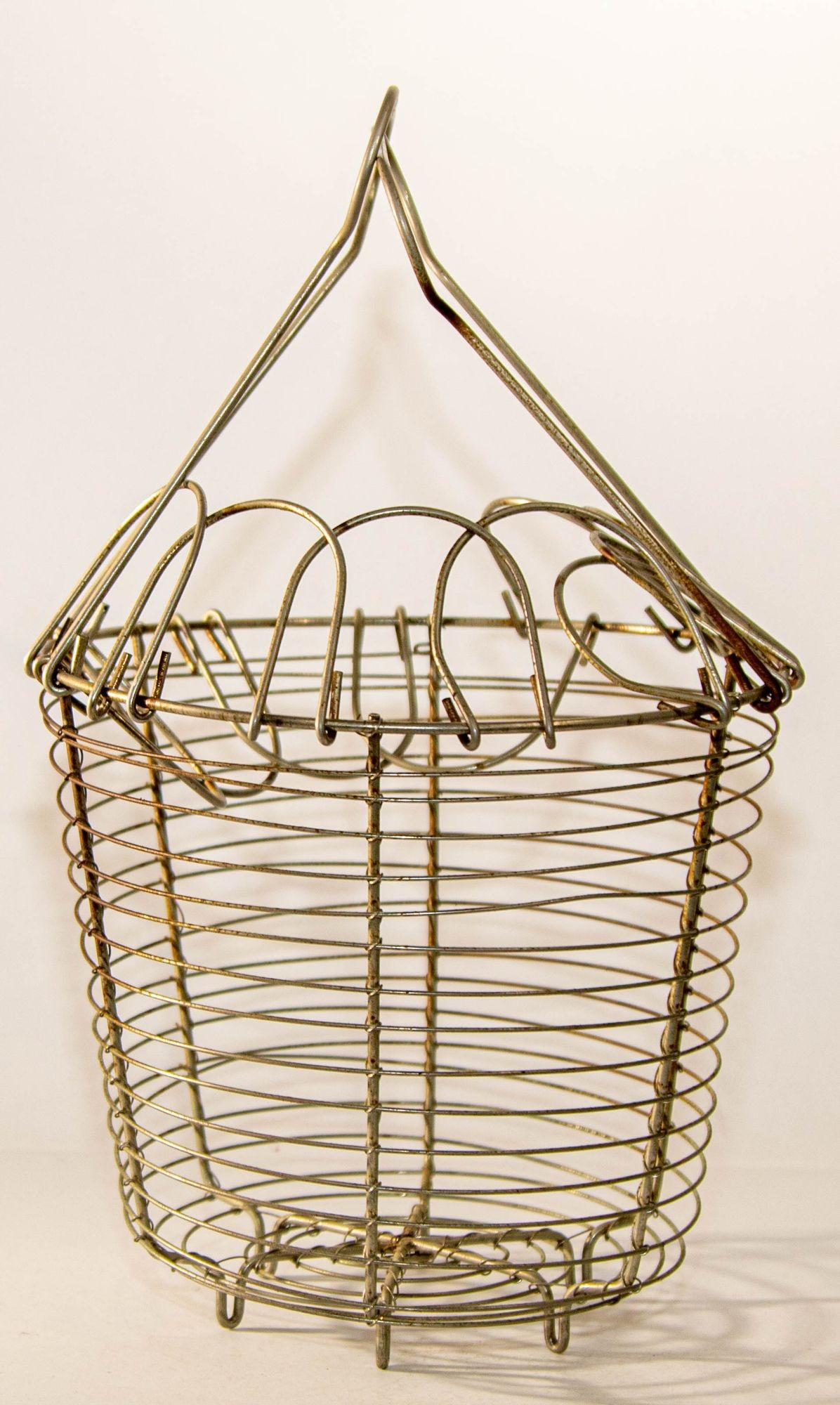 Antique French metal wire egg decorative basket, rustic French farmhouse decor with collapsible zigzag lids and two folding handles, loop feet, the basket has a decorative fold-down daisy-loop top to secure the contents in the basket.
This early