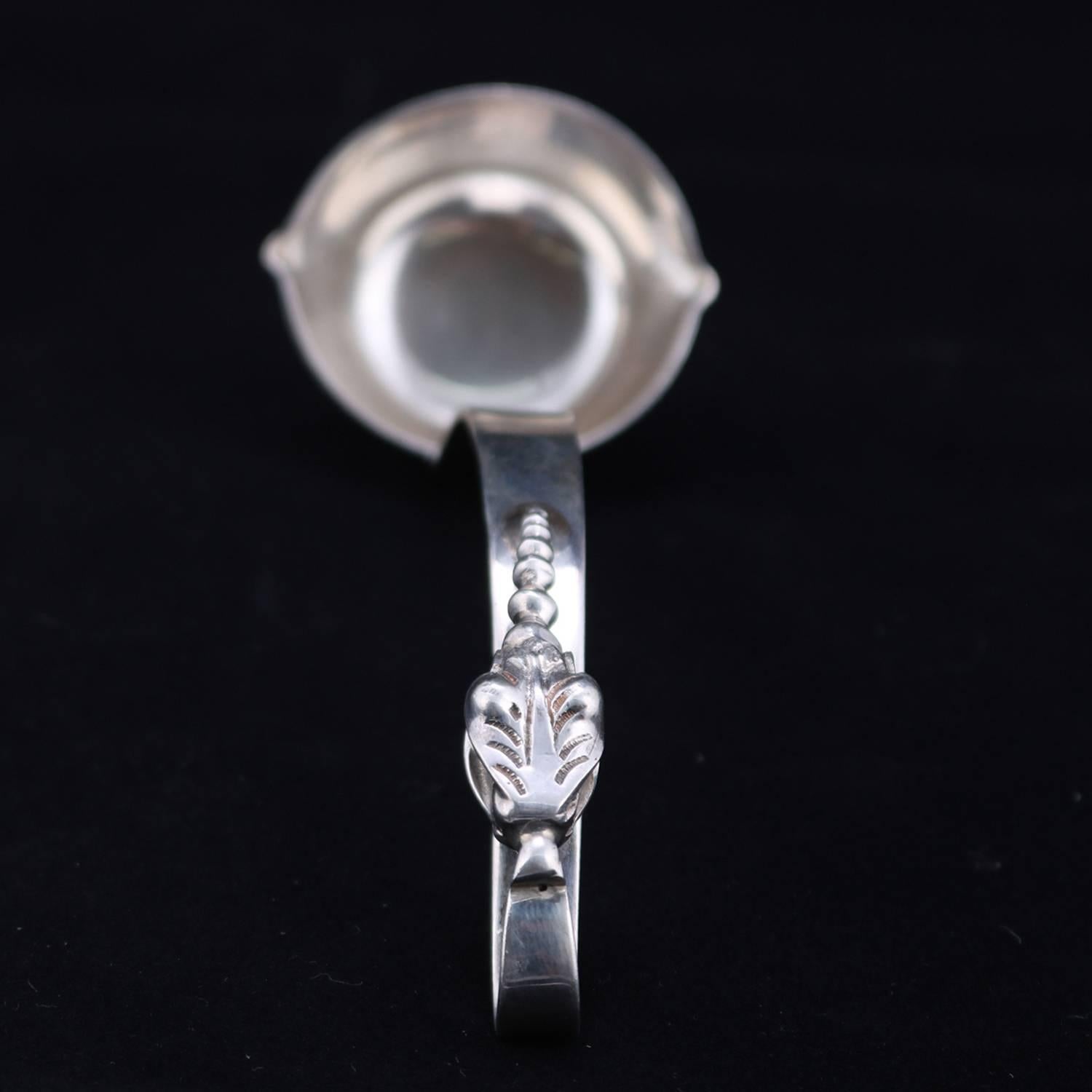 Mexican sterling silver serving sauce ladle features open handle with applied stylized foliate decoration, bowl with opposing pour spouts marked en verso Made in Mexico and Sterling, 2.54 toz, circa 1880.

***DELIVERY NOTICE – Due to COVID-19 we are
