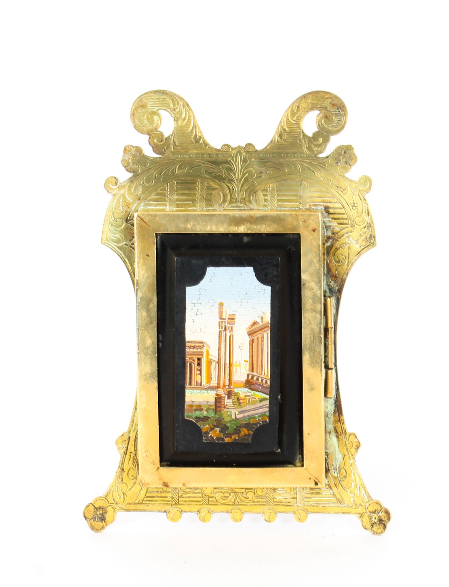This is a beautiful antique Grand Tour Italian micro mosaic mounted ormolu easel photograph frame, 19th century in date.

The hinged cover decorated with a mesmerizing micro mosaic panel of Roman ruins Rome, with a padded silk back bearing the