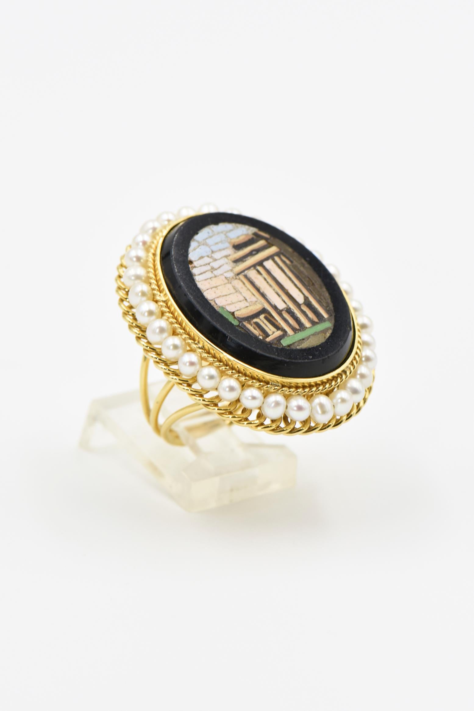 Ce micromosaïque du milieu du XIXe siècle présente une scène romaine dans un morceau de marbre noir.   Cette pièce ancienne a ensuite été transformée en une bague en or jaune 14k. Ce montage fait à la main met en valeur le design.  Le cadre est