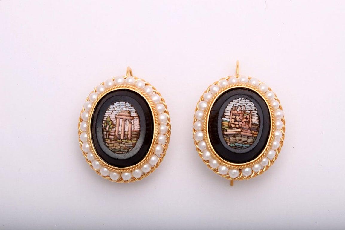 These mid 19th century micromosaics feature Roman scenes set into a piece of black marble.   These antique piece was later made into a 14k yellow earrings. These hand made mountings highlight the mosaic's design.  The frame has a twisted gold frame