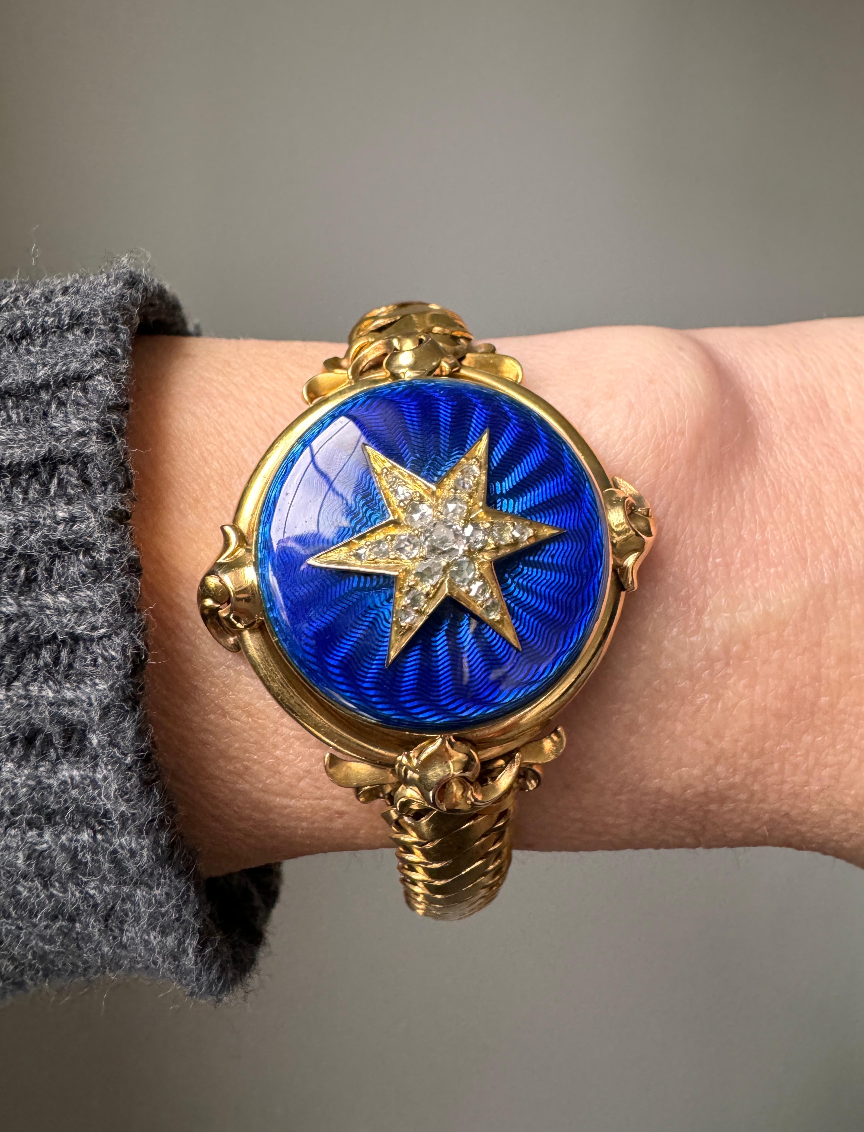 This exceptional antique locket bracelet, circa 1870s, sparkles with a six-rayed diamond-set star mounted atop a cobalt blue guilloche enamel cover. The supple S-link bracelet culminates in a concealed push clasp with safety chain. Fits a petite 6