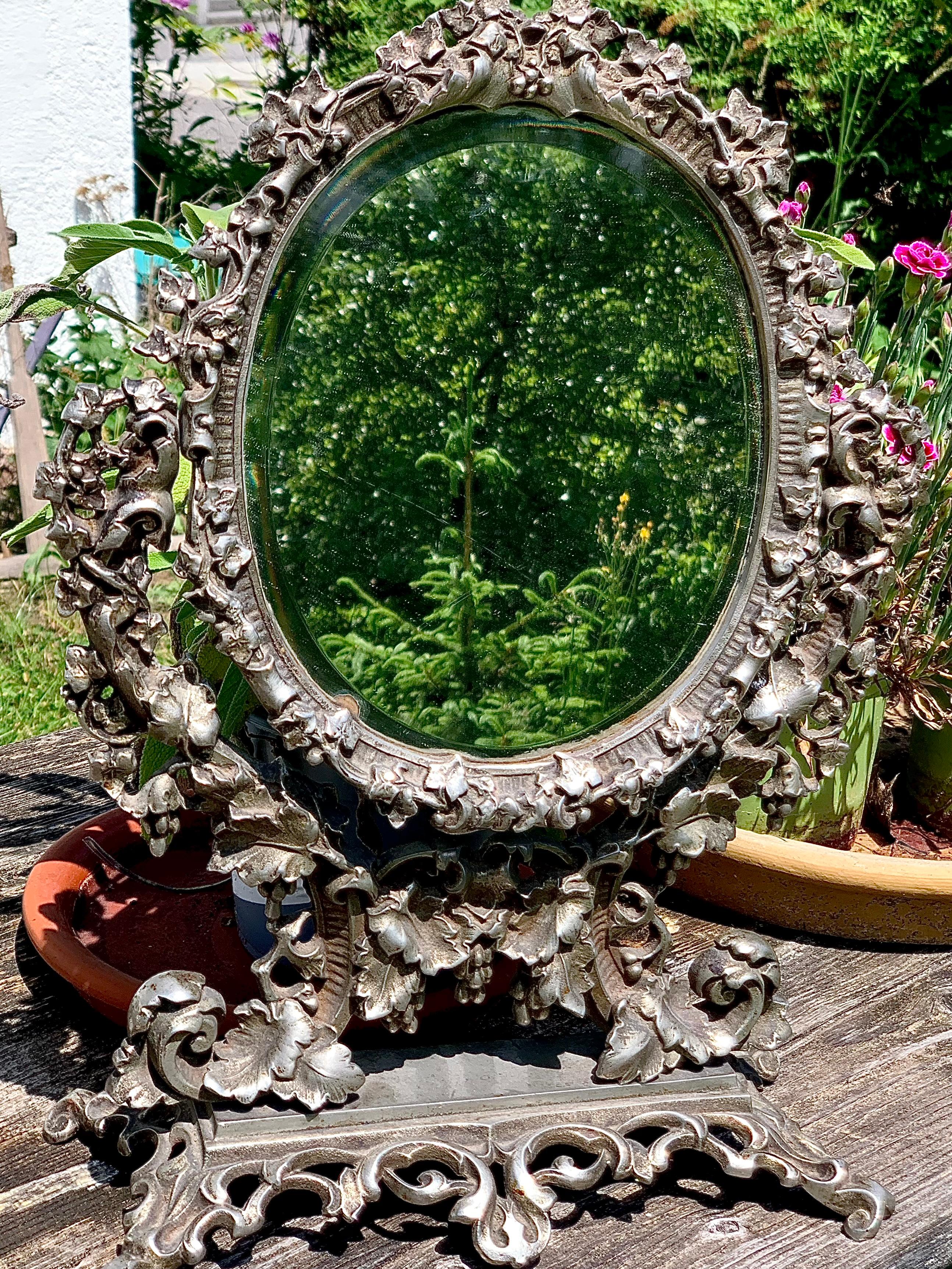 This revolving mirror has been made out of cast iron in the third quarter of the nineteenth century in a German art foundry. It has been cast fom a beautifully molded modell and has a rich and sumptuous feel to it.
It celebrates the autumn, vine