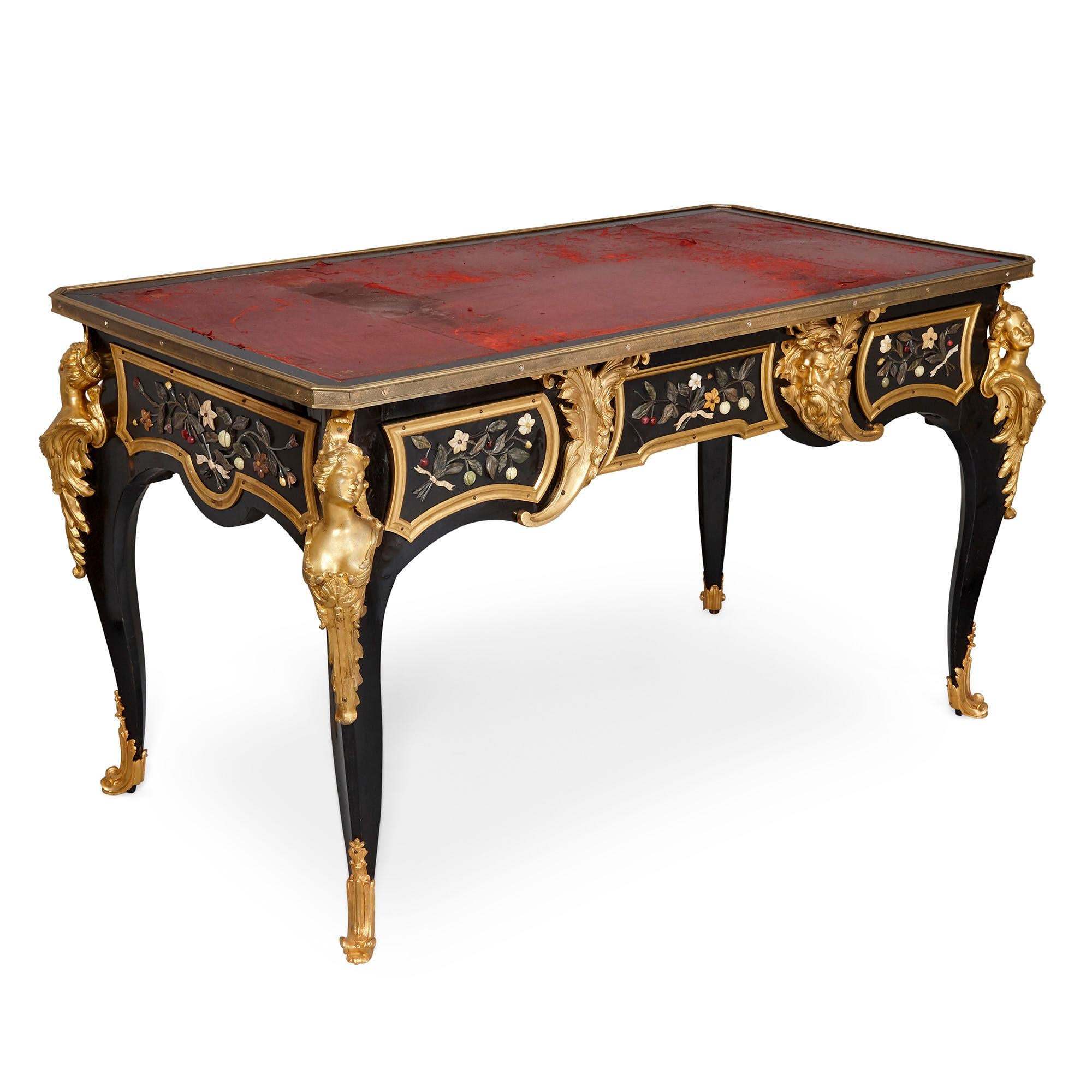 Antique Mid-19th century ebonised wood, gilt bronze and Pietra Dura desk,
French, c. 1860s
Dimensions: Height 77cm, width 134cm, depth 78cm

This Napoleon III period desk features a wonderfully eclectic design, blending together elements of the