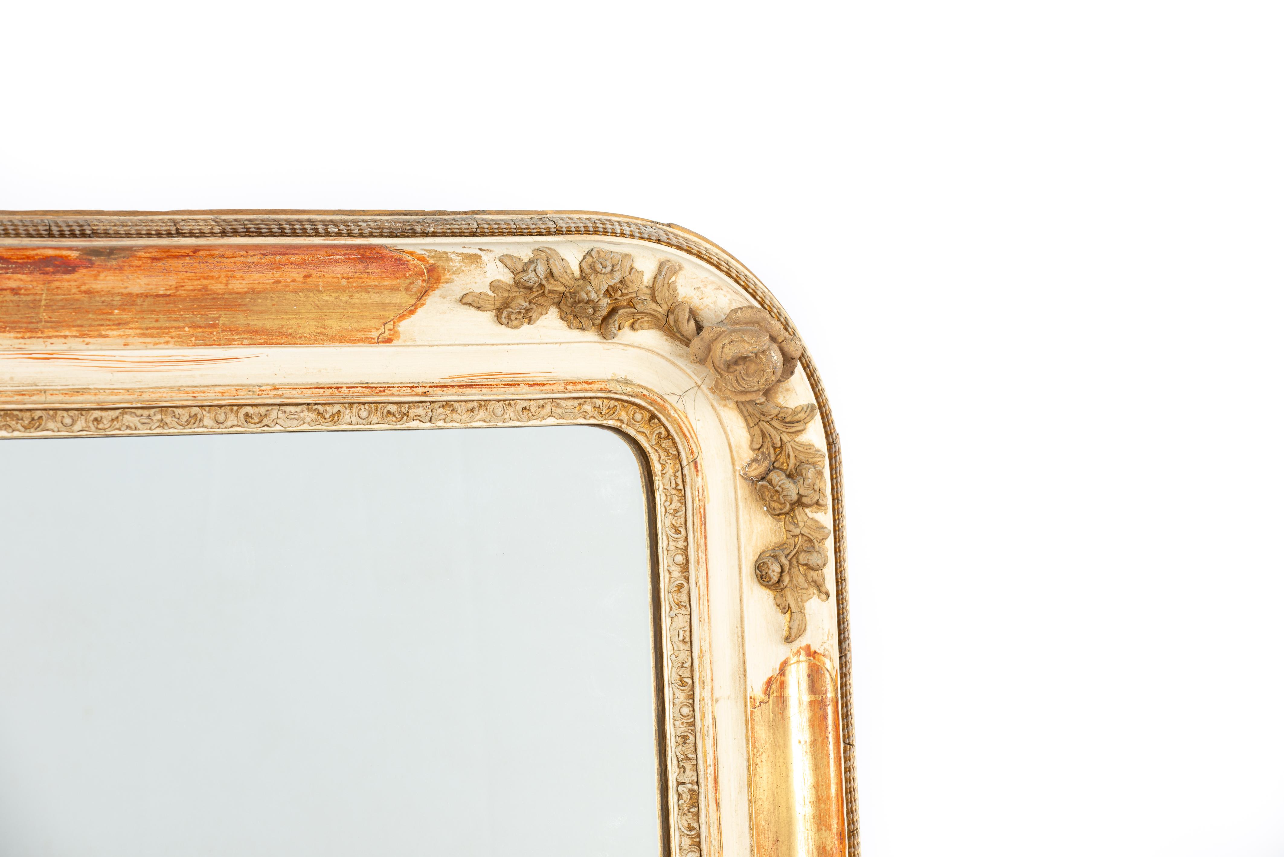 This antique mantel mirror was crafted in southern France in the mid-19th century. The mirror features quarter-round top corners, characteristic of the Louis Philippe style. Its frame is made of solid pine wood, smoothed with gesso. The mirror was