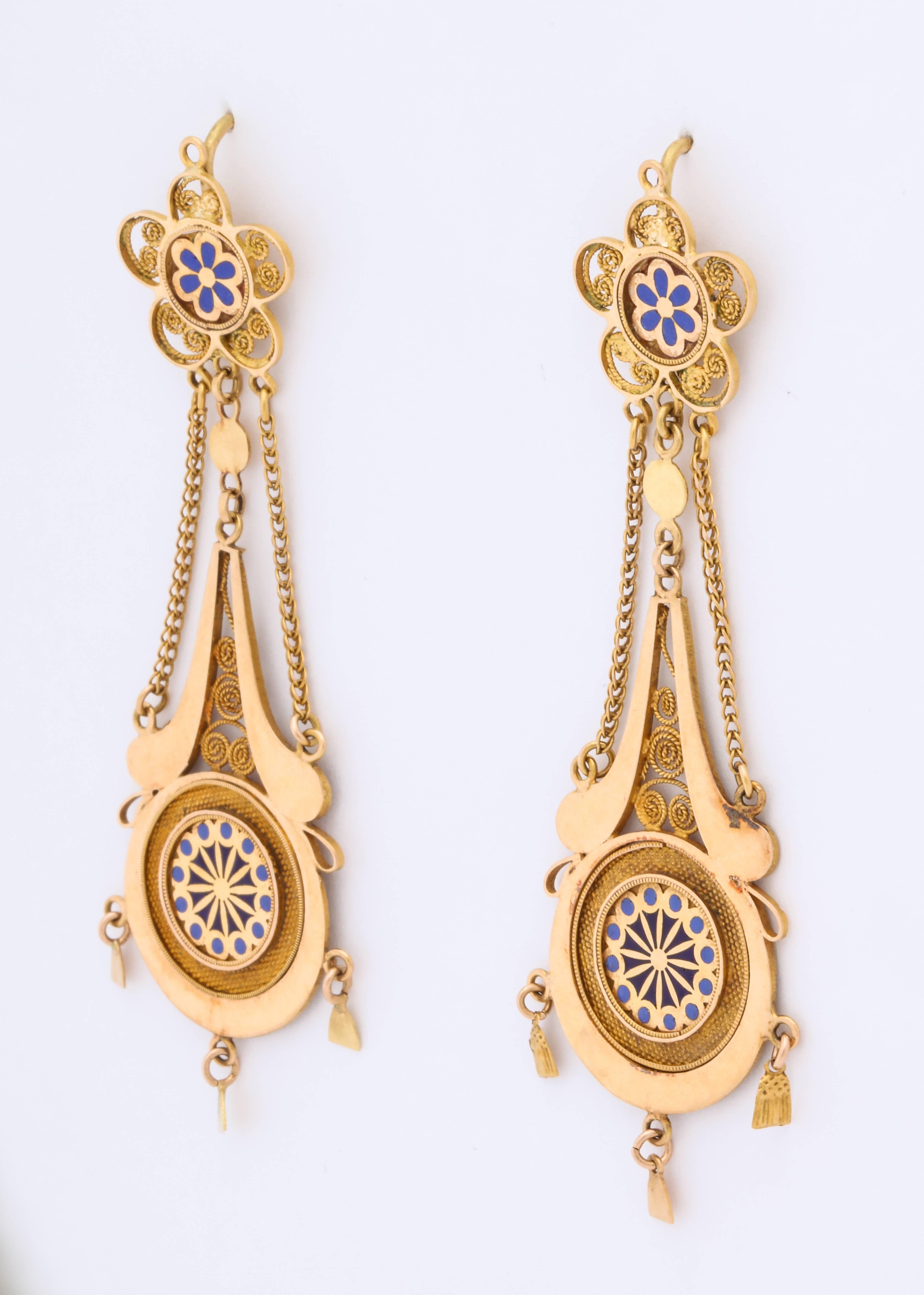 Magnificent French 18 kt chandelier earrings c. 1800 are featherweight, and of amazing workmanship with their enamel daisy, geometric lower design, cannetille coils and three small bells at bottom. Chains suspend the sections of these earrings as