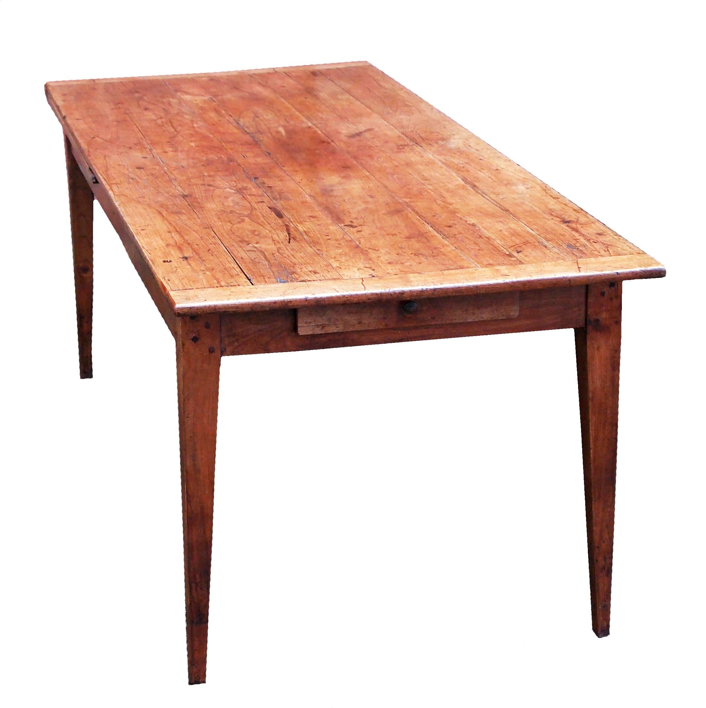 A very attractive mid-19th century french cherrywood extending farmhouse dining table
having superbly figured plank top with cleated ends, frieze drawer to one end and
draw leaf extension to other raised on elegant square tapered