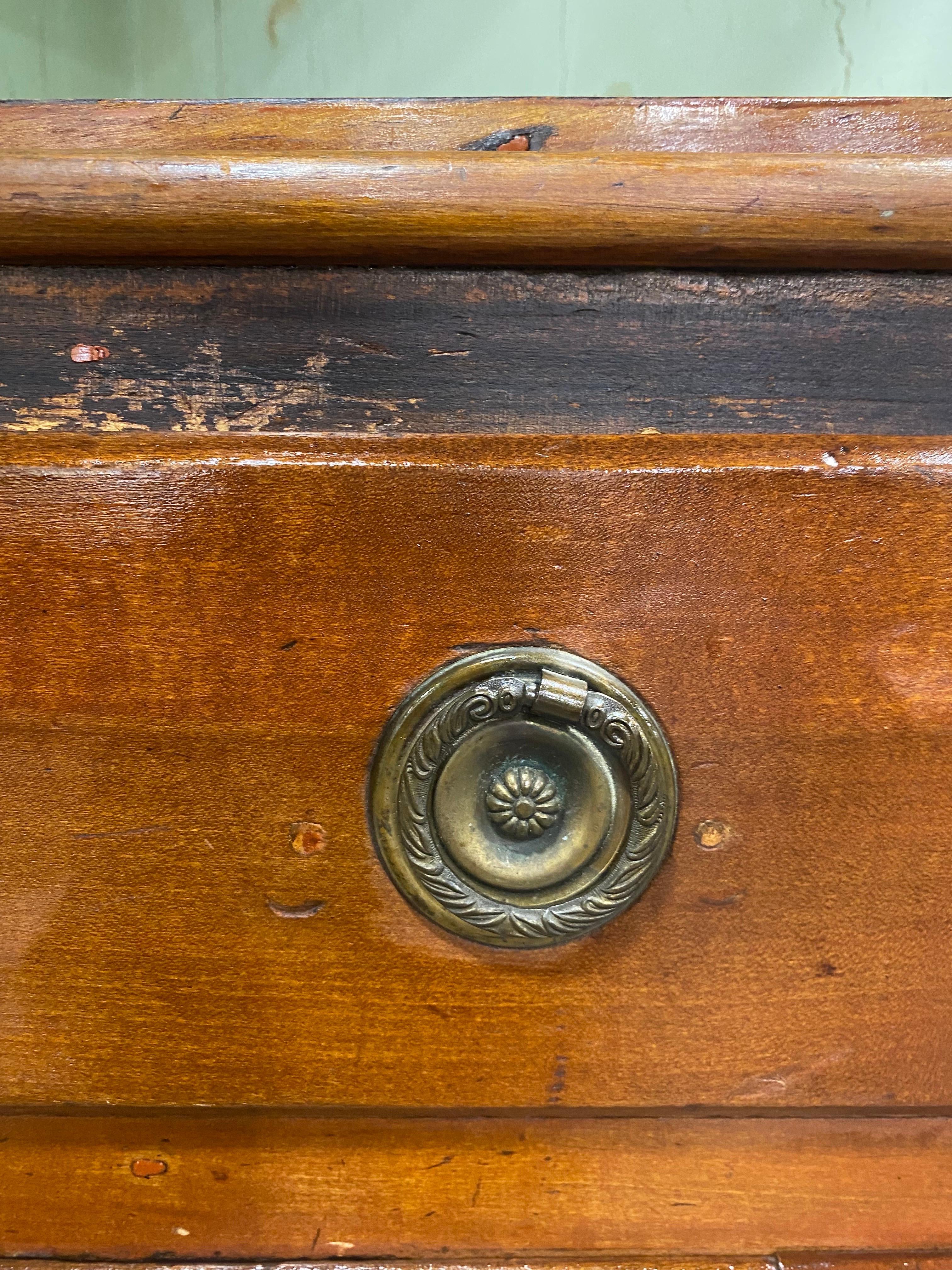 This is a mid-19th century handmade antique cherrywood corner cabinet. This classic American antique features hand blown individual glass panels to the front door with its original glass knobs. This handmade cabinet has a beautiful antique patina to