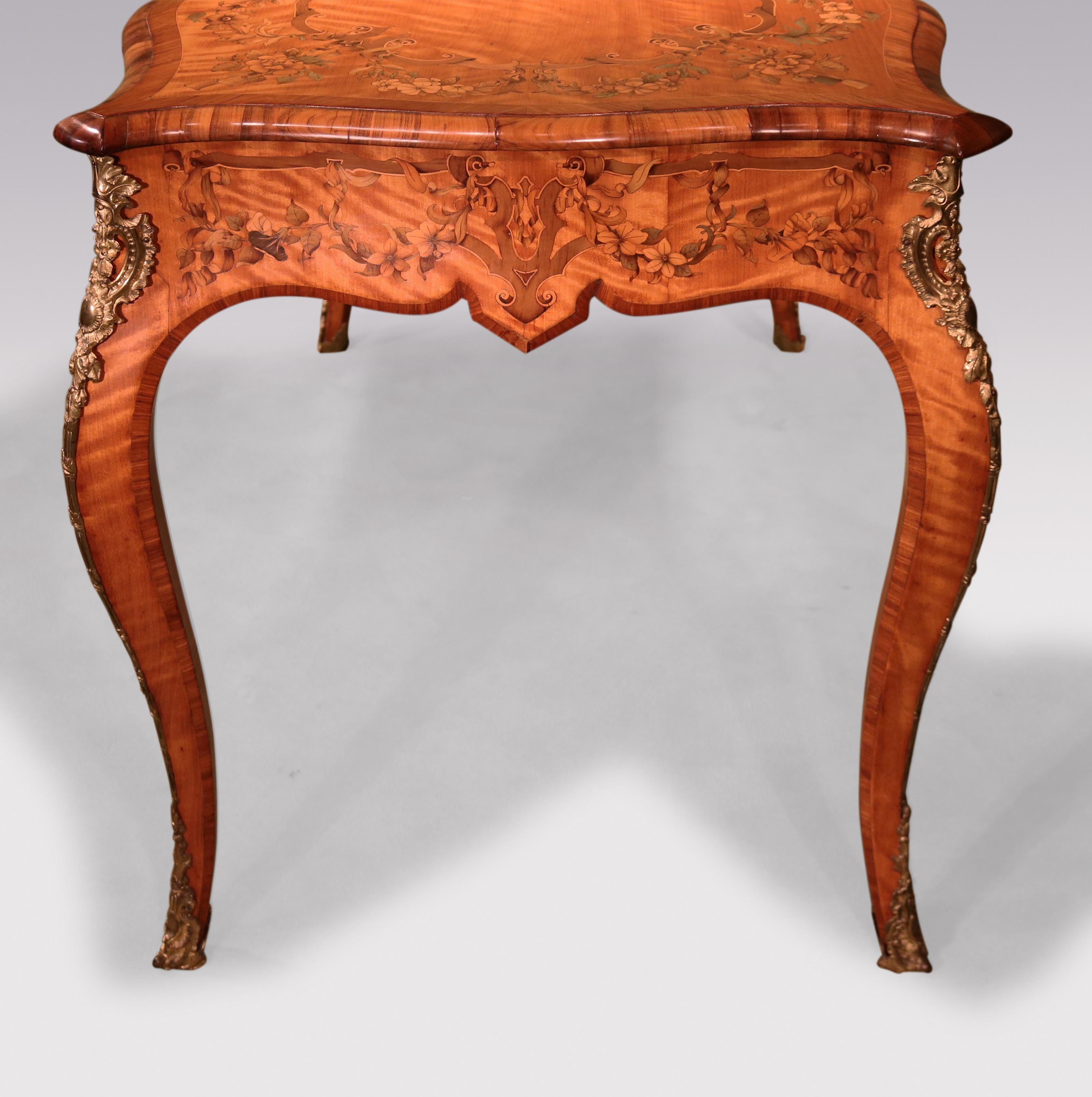 An unusual fine quality mid-19th Century serpentine-shaped Writing Table, having coromandel end-grain moulded edge top and tulipwood crossbanding throughout.  The Table, profusely inlaid with strapwork & flower garlands, supported on cabriole legs