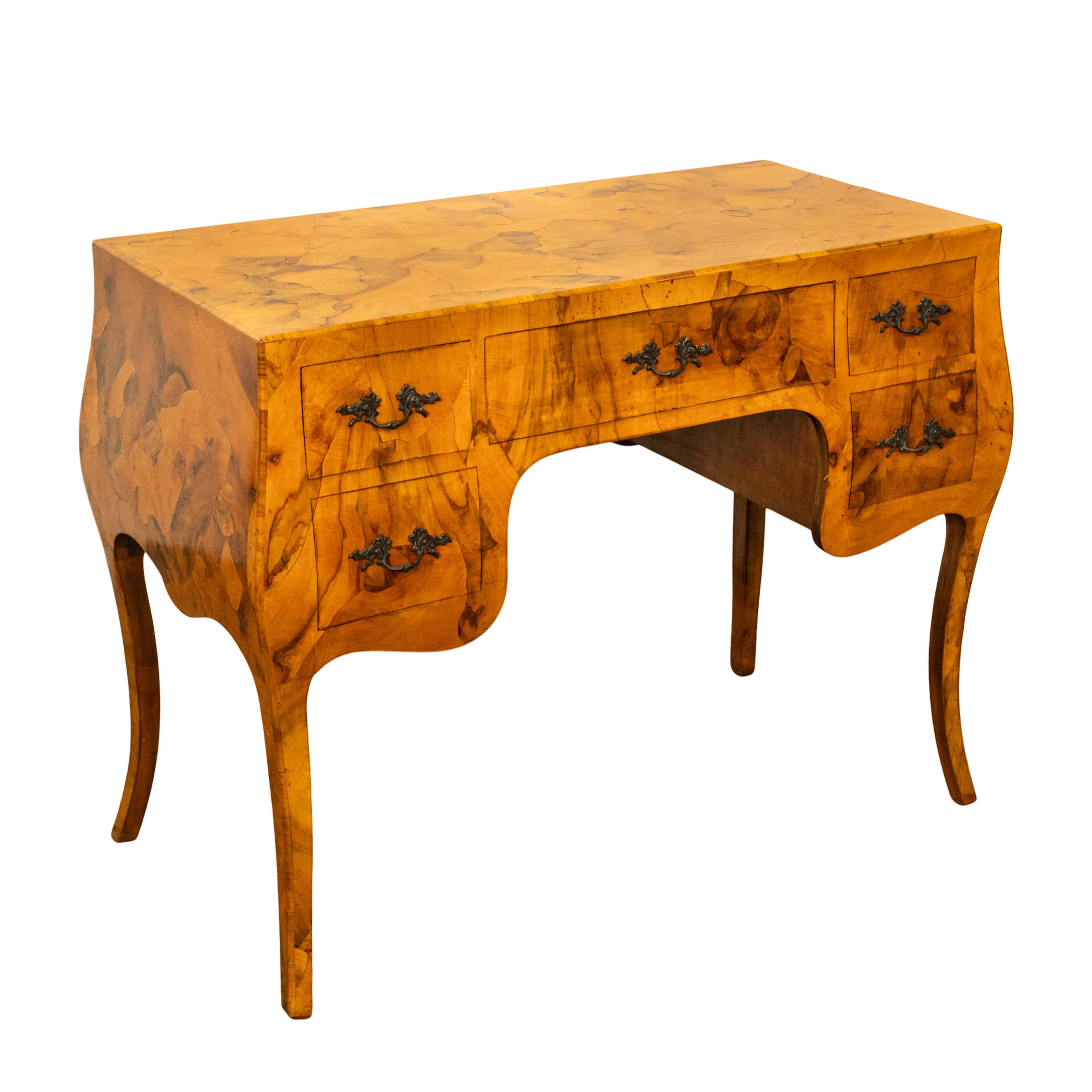 A very handsome Italian burl olive-wood 'oyster' bombe shaped desk.
The desk of a bureau plat shape and having a very pleasing patchwork of 'oyster' shaped burl olive-wood, the desk having a bombe shape on all four sides. The desk having a knee-hole