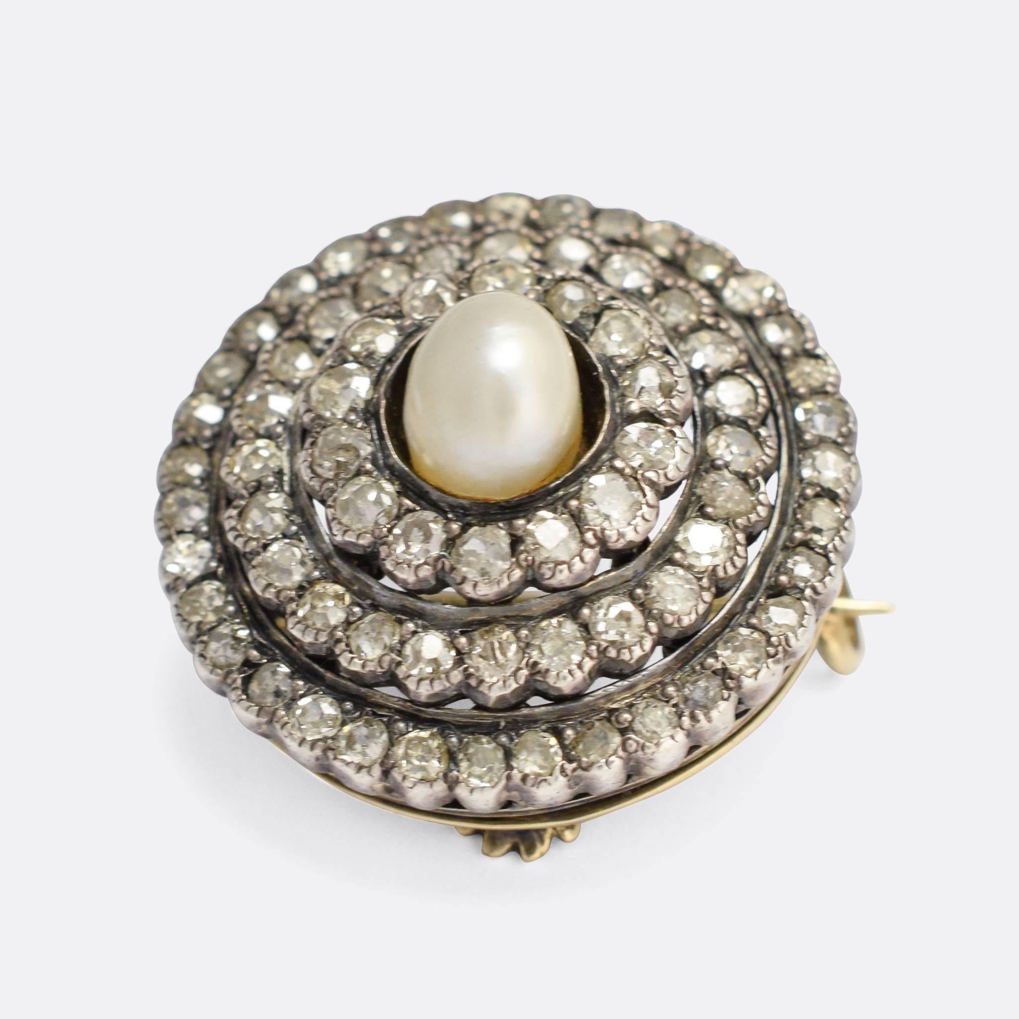 A beautiful antique pendant, dating to the mid 19th Century. It's set with a central natural pearl surrounded by a triple halo of old cut diamonds - their total weight is around three quarters of a carat. The piece remains paired with both the