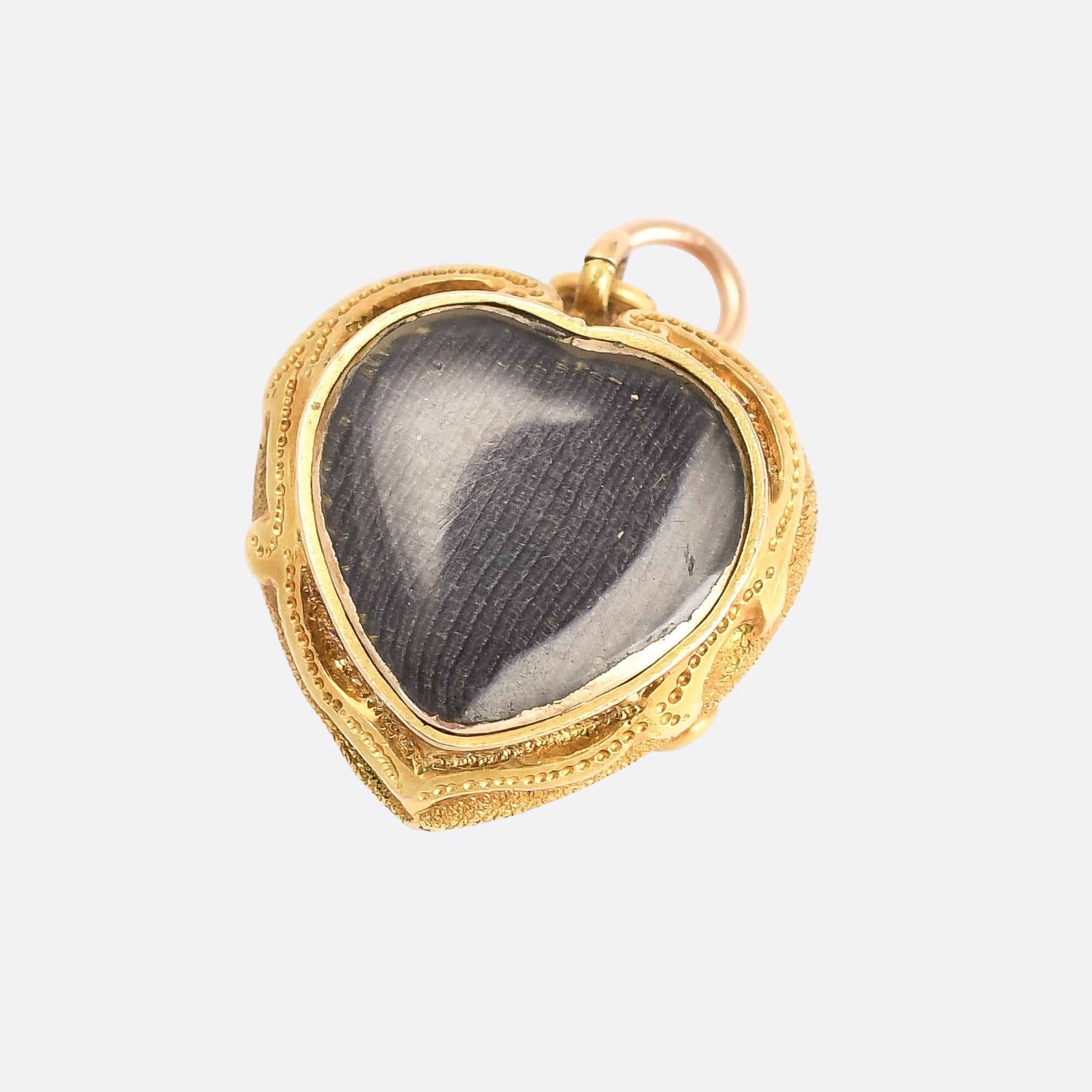 A beautiful mid-Victorian heart locket set with three egg-shaped turquoise cabochons. The back features a heart-shaped glass locket compartment, and the stones on the front are surrounded by rococo-inspired foliate goldwork on a finely textured