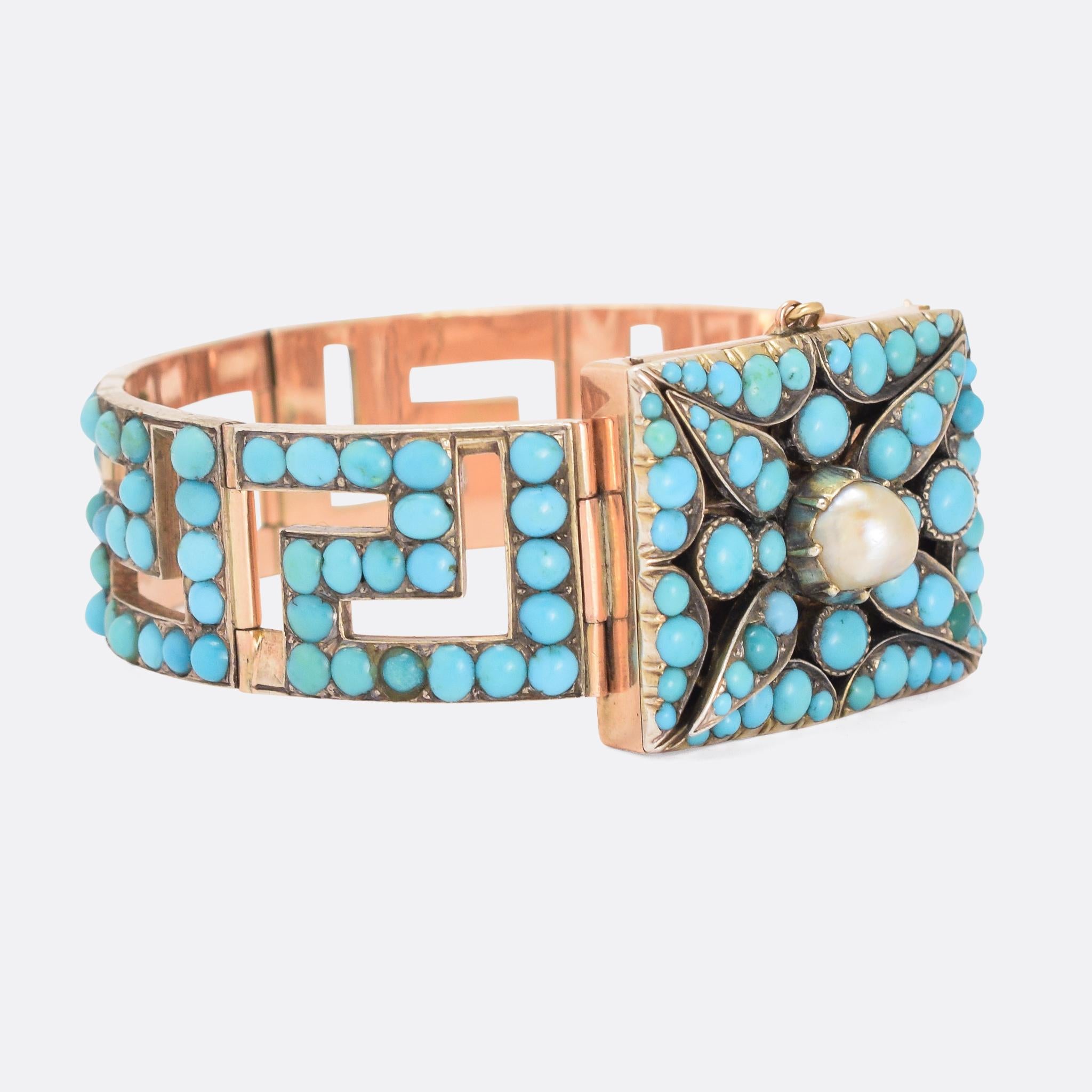 An incredible mid Victorian bracelet set with Persian turquoise and pearl. The rectangular head is formed as a stylised flower, with pearl centrepiece, and the band features an openworked Greek Key motif all the way around. It's a bold, substantial