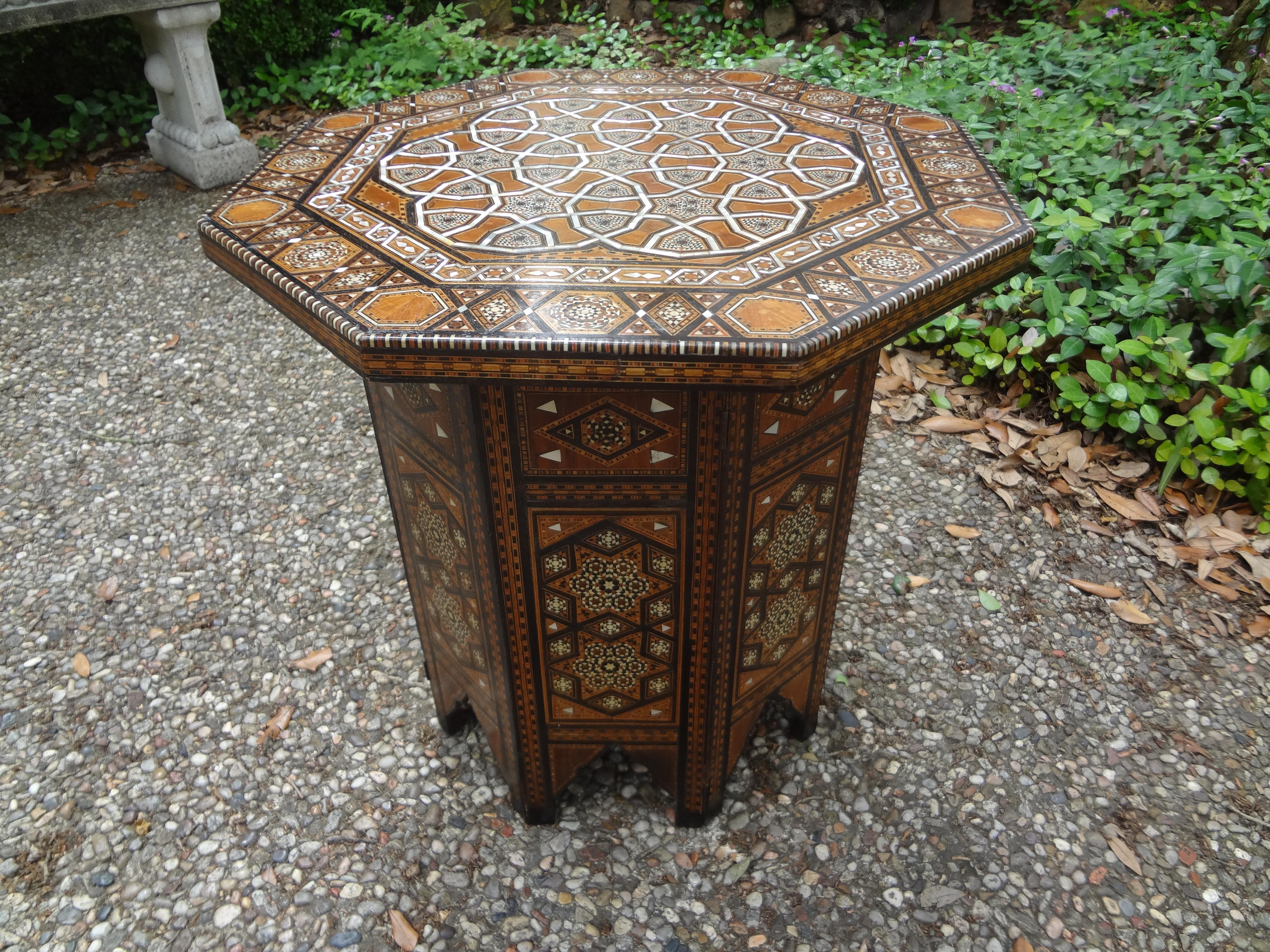 Antique Middle Eastern, Moroccan or Moorish Arabesque style octagonal side table. This beautiful table has a great pattern with alternating intricately inlaid mixed woods and mother-of-pearl in striking geometric pattern. Detailed and edged in camel