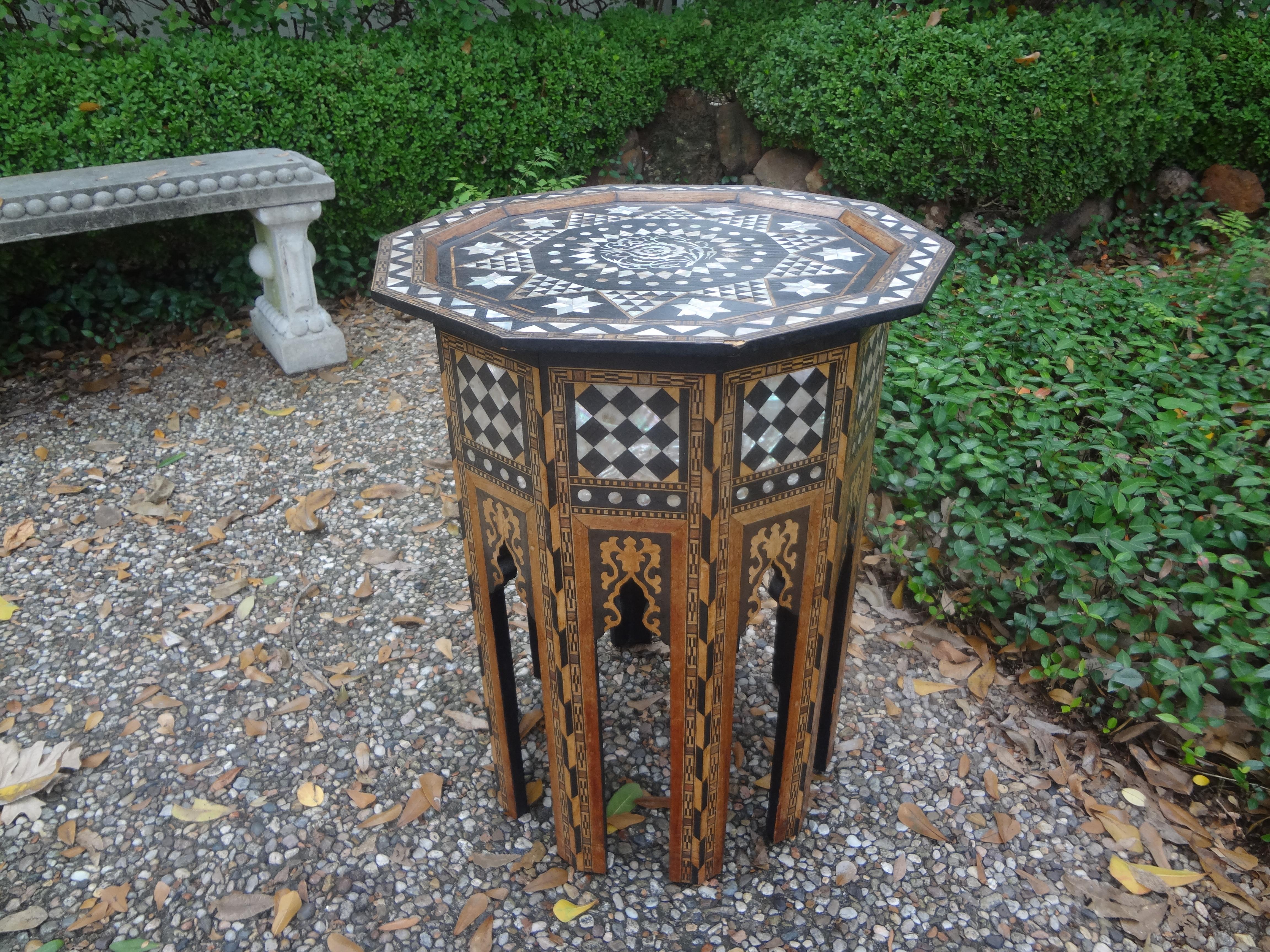 Antique Middle Eastern, Moroccan or Moorish Arabesque style octagonal side table. This beautiful table has a great pattern with alternating intricately inlaid mixed woods and mother-of-pearl in striking geometric pattern. Detailed and edged in camel