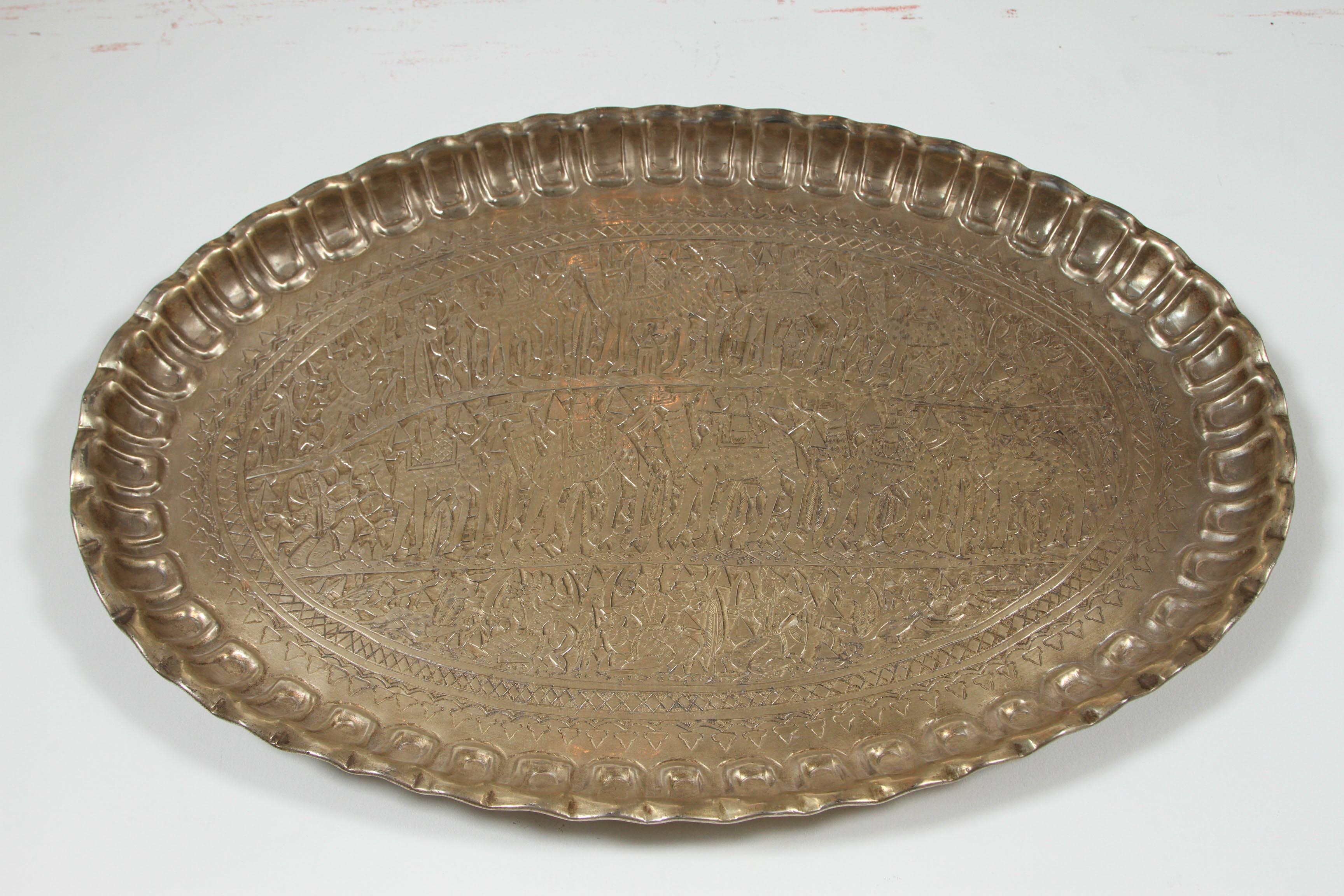 Antique Middle Eastern Egyptian wall hanging charger tray.
Silver color metal with pictural scene of figures, camel, lions and pyramids.
Pie crust with geometric Moorish design, Museum quality piece.
Nicely handcrafted and hand-carved with floral